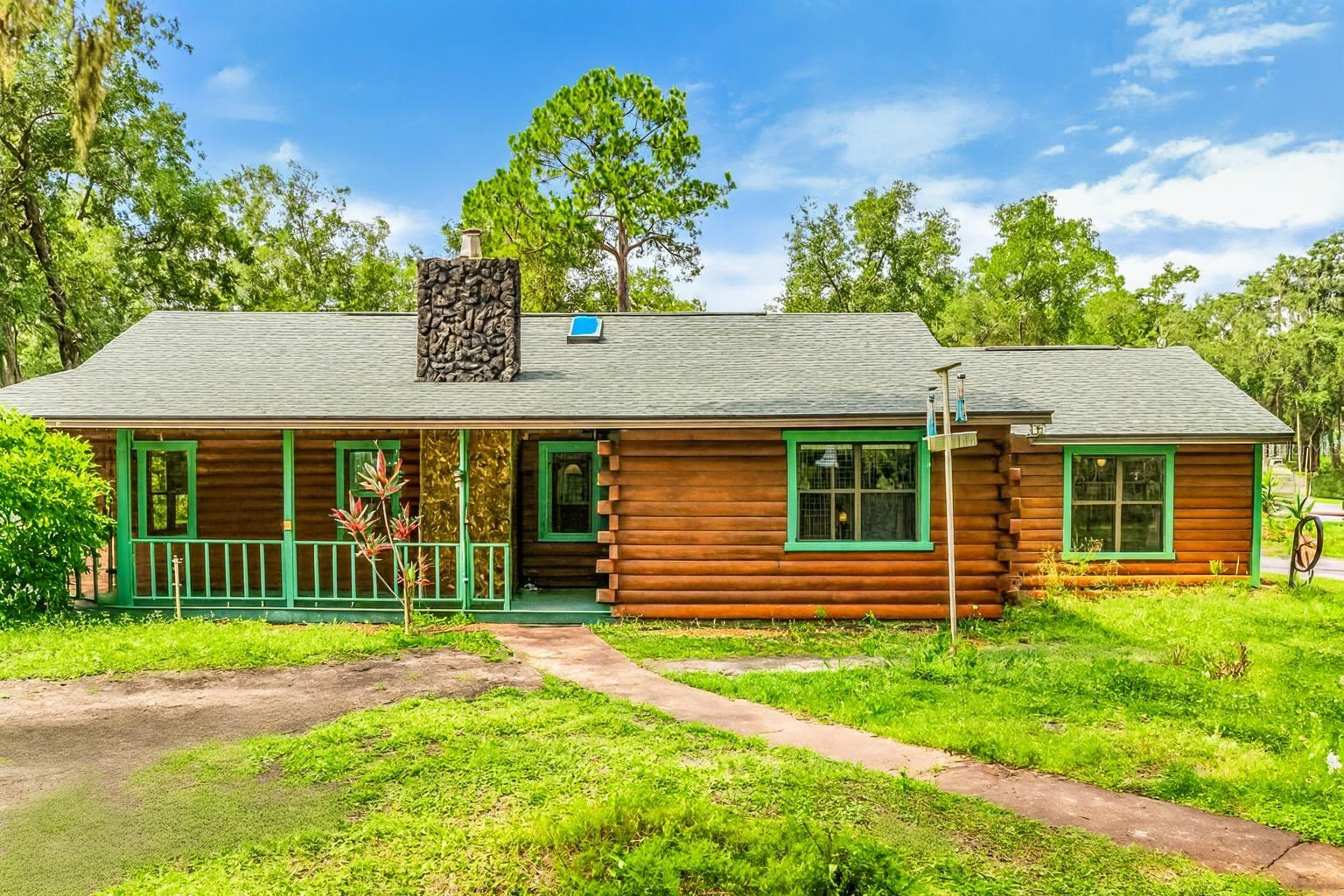 One or more photo(s) has been virtually staged. Enjoy your OASIS RETREAT from the hustle, bustle & traffic. Allow yourself to disconnect or stay connected(your preference) living in this BEAUTIFUL SPACIOUS LOG CABIN HOME on 5 + ACRES(FULLY FENCED with GATE). *BRING YOUR HORSES or YOUR FARM ANIMALS. They will love this property* Enjoy the RUSTIC CHARM & UPDATED features of this Home, while benefiting with a ***NEW ROOF (2025), NEW WATER HEATER (2025), AC (NEW from 2017), BRAND NEW KITCHEN STAINLESS STEEL APPLIANCES*** The Home offers 5 SPACIOUS BEDROOMS (5th Bedroom can be also used as a FAMILY ROOM/OFFICE or flexible to your needs! *This home is perfect for the New Owner that enjoys LOTS OF SPACE and being CONNECTED in this OPEN FLOOR PLAN HOME.* **The home is perfect for MULTIGENERATIONAL LIVING, with one of the bedrooms offering its own PRIVATE ENTRANCE, WALK-IN CLOSET & ADJACENT BATH, ideal for an IN-LAW SUITE or GUEST QUARTERS.** Everyone will love gathering together in the OPEN LIVING AREA that is highlighted with elegant EXPOSED CEILING BEAMS, SKYLIGHTS & a COZY STONE ACCENTED FIREPLACE. **The kitchen comes FULLY EQUIPPED FOR CHEFS with STUNNING GRANITE COUNTERTOPS, BRAND NEW STAINLESS STEEL APPLIANCES, a LARGE BREAKFAST BAR that seats 4+, and LOTS OF CABINET SPACE.** ***Relax in the comforts of the OWNER'S SUITE, where you’ll find a SPACIOUS BEDROOM with SERENE VIEWS, LARGE WALK-IN CLOSET and EN-SUITE BATH.*** ***The LARGE 5TH BEDROOM/BONUS ROOM enjoys views of the SCREENED-IN PATIO.*** A COVERED FRONT PORCH with PORCH SWING makes you want to grab your lemonade or coffee and admire the quietness. **The SCREENED-IN PATIO & ADDITIONAL PATIO gives you plenty of ways to relax, entertain and enjoy the outdoors. A PRIVATE WOOD FENCED YARD off the Screened-In Patio is great for your Furry Friends that need to be contained to a smaller area or a PLAY AREA.** The whole property is FULLY FENCED-IN with GATE ACCESS only from the road. *The LARGE PROPERTY OFFERS much more areas to EXPAND if the new owner wishes.* The WORKSHOP/HOBBY Room includes a SCREENED-IN area and has electric and water connected. This home is minutes away from Schools, Shopping, Restaurants, Medical & more. It is only 45 minutes to Orlando and Ocala. Only minutes away from the Ocala National Forest. Don’t miss this unique opportunity to make this beautiful home & lifestyle yours!