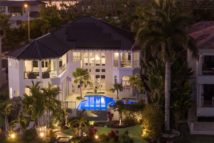 Discover refined living and tranquility in this stunning home set within the esteemed Lido Shores neighborhood. Step inside through striking Sapele entry doors into a thoughtfully remodeled residence by award-winning Mindy Webb Design. The instant you enter, you're greeted by a breathtaking wall of windows that highlights the infinity pool, sweeping views of Sarasota Bay, the city skyline, and the impressive John Ringling Bridge. Inside, a contemporary color palette and premium finishes elevate every room. The spacious five-bedroom estate reveals meticulous craftsmanship throughout, with Italian flooring, a gourmet chef’s kitchen, butler’s pantry, billiard room, two wet bars, a climate-controlled wine cellar holding up to 648 bottles, intricate crown molding, tray ceilings, an office/den with embossed copper ceiling, and a two-stop elevator. The master suite, on the main floor, includes dual, custom walk-in closets and a spa-like bathroom. An extraordinary collection of chandeliers throughout the home adds a touch of elegance. Three of the additional en-suite bedrooms provide comfort for guests or family, the show-stopping wine cellar , with new cooler, will delight any enthusiast. Start your mornings peacefully, taking in the kaleidoscope of hues as the sun rises over the bay, watch dolphins and manatees glide by. Relax at night beside a fire on the upper balcony, enjoying views of the glowing Ringling Bridge and Sarasota skyline. Outdoor features include a summer kitchen, two separate dining spaces, a 16,000 lb. boat lift capable of accommodating deep-hulled vessels, two Jet Ski lifts, a dedicated kayak/paddle boat platform measuring 9 feet by 14 feet with an integrated rack, as well as an additional dock platform sized at 16 feet by 9 feet.  Sustainable updates abound, like 51 new solar panels paired with three Tesla storage batteries. Additional features: four-zone Trane air system, fenced yard, brand-new metal roof (2025). The professionally landscaped grounds feature native Florida foliage, palm trees, and ambient lighting for evening gatherings. Furniture available via separate contract.
End your day with a stroll along your community-private beach. Lido Shores Association membership is voluntary ($500/year) for access to a private gated beach, pavilion, Bocci Ball Court, and many community events. This home has been expertly renovated and meticulously maintained—simply bring your suitcase and move right in!  
Located minutes from boutique shopping, fine dining, cultural venues, and St. Armands Circle, residents also enjoy proximity to world-class golf courses and recreational parks. The residence promises both privacy and community, offering a tranquil retreat while being close to Sarasota's vibrant coastal lifestyle.