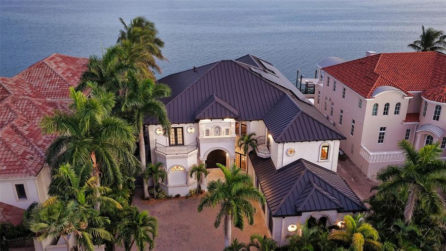 Discover refined living and tranquility in this stunning home set within the esteemed Lido Shores neighborhood. Step inside through striking Sapele entry doors into a thoughtfully remodeled residence by award-winning designer Mindy Webb of Mindy Webb Design. The instant you enter, you're greeted by a breathtaking wall of windows that highlights the infinity pool, sweeping views of Sarasota Bay, the city skyline, and the impressive John Ringling Bridge.
Inside, a contemporary color palette and premium finishes elevate every room. The spacious five-bedroom estate reveals meticulous craftsmanship throughout, with Italian flooring, a gourmet chef’s kitchen, butler’s pantry, billiard room, two wet bars, a climate-controlled wine cellar holding up to 648 bottles, intricate crown molding, tray ceilings, an office/den, and a two-stop elevator. The master suite on the main floor includes dual custom walk-in closets and a spa-like bathroom, while an extraordinary collection of chandeliers adds a touch of elegance. Three of the additional en suite bedrooms provide comfort for guests or family, and the show-stopping wine cellar will delight any enthusiast.
Start your mornings peacefully, taking in sunrise hues over the bay, watching dolphins and manatees glide by, or relax at night beside a fire on the upper balcony, enjoying views of the glowing Ringling Bridge and Sarasota skyline. Outdoor features include a summer kitchen, two separate dining spaces, a 16,000 lb boat lift, two Jet Ski lifts, a Kayak/Paddle Boat platform (9' x 14') with rack, and an additional 16' x 9' platform.
Sustainable updates abound, like 51 new solar panels paired with three Tesla storage batteries. End your day with a stroll along your private beach. This home has been expertly renovated and meticulously maintained—simply bring your suitcase and move right in! Additional upgrades include a new four-zone Trane air system (2018) and full fencing with gate access.
BONUS: A brand-new roof was installed in 2025. NOTE:  Furniture can be purchased on a separate contract.