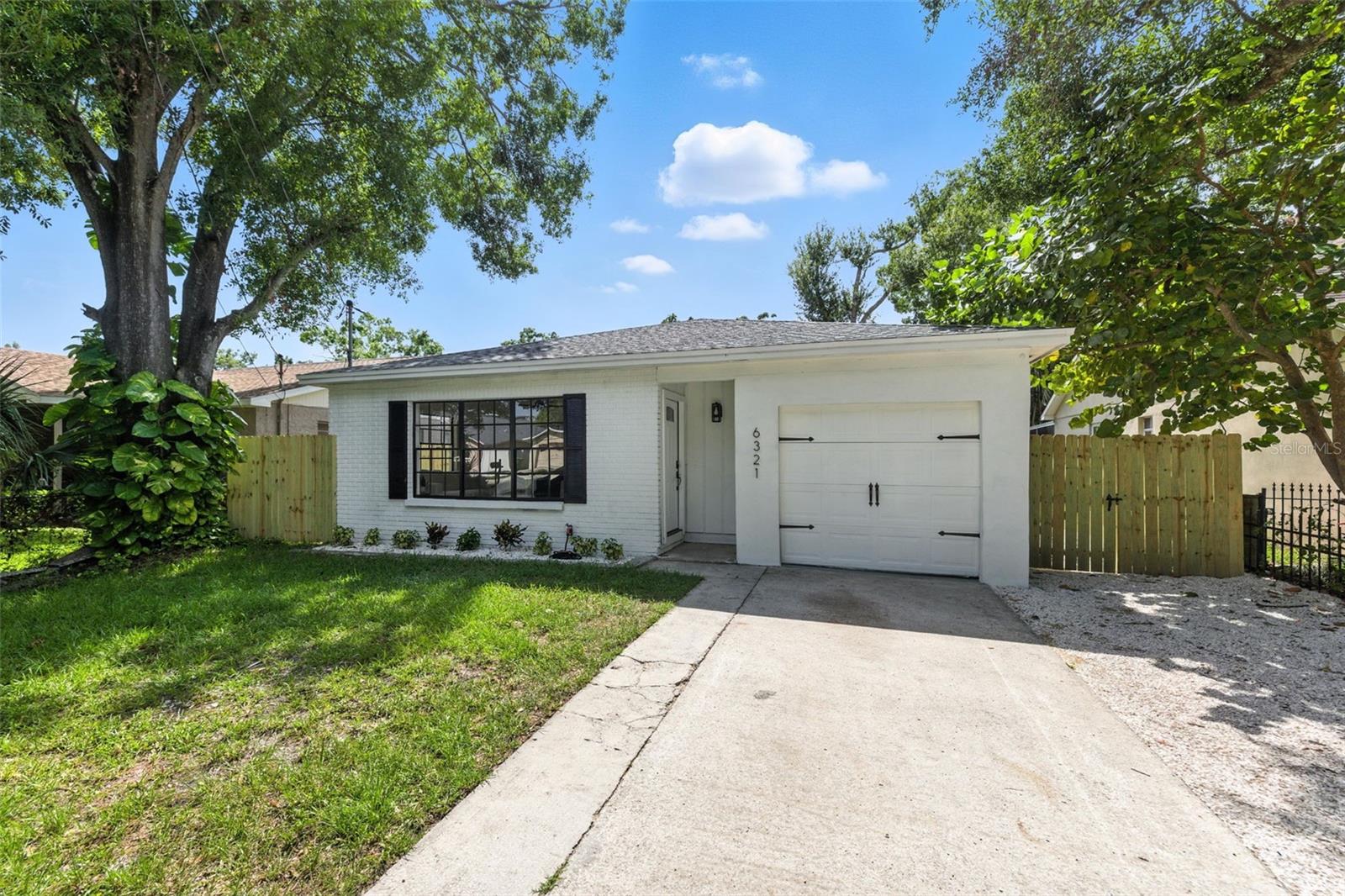 Completely remodeled from top to bottom, this stylish 3-bedroom, 2-bathroom block home with attached one car garage offers modern comfort and peace of mind in the heart of South Tampa. Located in desirable Flood Zone X, the property remained high and dry during the 2023 storms. With a brand-new roof (2025) and newer AC system (2020), this move-in-ready gem has been thoughtfully updated throughout. Step inside to a bright, open-concept layout where living, dining, and kitchen spaces flow seamlessly together. The kitchen is a total showstopper—featuring quartz countertops, custom shaker cabinetry, designer tile backsplash, stainless steel appliances, and high-end finishes that make everyday living feel elevated. Luxury vinyl plank flooring runs throughout the home, complemented by fresh paint, designer lighting, and stylish fixtures. Just off the kitchen, a versatile flex space with new sliding glass doors opens to a fully fenced backyard with fresh landscaping—perfect for pets, play, or entertaining.The private primary suite features a walk-in closet, modern barn door, and beautifully updated en-suite bath. Two additional bedrooms offer generous closet space and share a fully remodeled bathroom with sleek, modern finishes. Additional perks include dedicated laundry room with storage cabinets and utility sink, attached 1 car garage with new garage opener, additional parking pad, no HOA and no CDD. Minutes to MacDill AFB, Bayshore Blvd, top-rated schools, shopping, and dining this professionally updated South Tampa home offers low-maintenance luxury with everyday functionality.