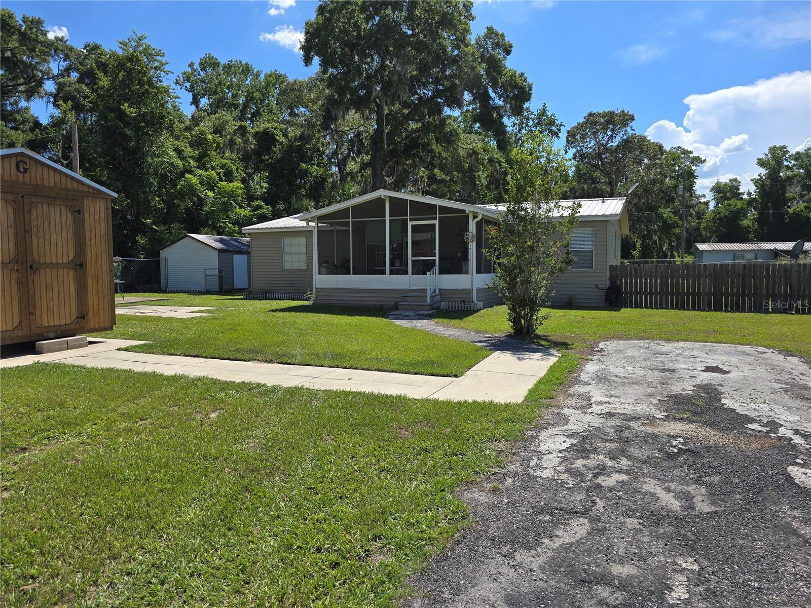 Charming, Updated, and Accessible — SELLERS MOTIVATED, BRING OFFERS. -- Welcome home to this well-maintained and thoughtfully upgraded 3 bedroom, 2 bath mobile home nestled on a spacious .41-acre fully fenced lot in peaceful Citra, Florida. Offering a perfect blend of comfort, functionality, and accessibility, this home is move-in ready and loaded with features that set it apart.
Inside, you'll find luxury vinyl plank flooring with a warm wood-look throughout the main living areas and bedrooms, while the remodeled primary bathroom showcases beautiful pebble stone flooring. The primary suite has been thoughtfully updated to include a wheelchair-accessible walk-in shower complete with a built-in bench for ease and comfort.
The spacious kitchen is both stylish and functional, featuring tile countertops, a large center island with ample storage, a stove, refrigerator, and microwave. The newly installed sliding glass door off the kitchen leads to a large covered back porch and boasts PD-Vinyl-Grids with argon gas insulation to help prevent condensation, ensuring clear views year-round.
Accessibility has been thoughtfully considered with custom-built ramps leading to the back porch and into the house via the sliding glass door. A newly installed 20-gauge steel front door provides peace of mind with superior durability and security.
The property offers plenty of outdoor space, including two large storage sheds and a detached one-car carport. The entire yard is enclosed with 6-foot chain link fencing for privacy and security, while the front gate has been conveniently designed at 4 feet to allow for easy package deliveries over the gate.
If you’re looking for a home that combines comfort, privacy, accessibility, and practical upgrades — all set on a generous lot — this property is a must-see!