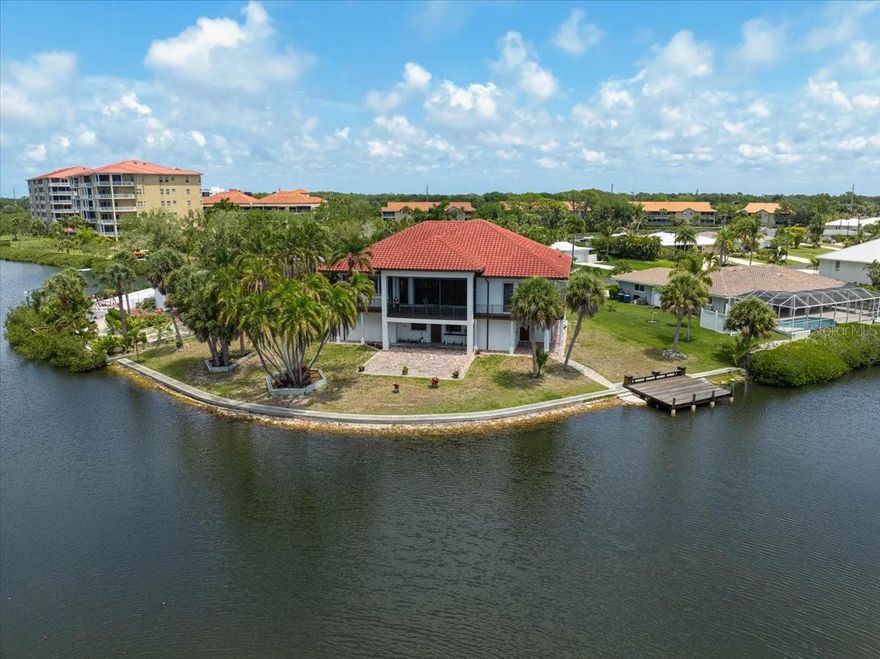**EXCEPTIONAL WATERFRONT RESIDENCE with 210 ft CANAL FRONTAGE** in desirable Sorrento Shores, offering Deep Water access with No Bridges to the Bay/Gulf.  Privately situated on a quiet cul-de-sac, the property enjoys tranquil water and palm views from nearly every room, with canals often visited by manatees and dolphins.  Built in 2011 with solid concrete block construction on both levels and encompassing 6,254 sq ft under roof, this residence is designed for durability and peace of mind. The elevated main living level at an 18 ft elevation, features Double-insulated Hurricane-Impact windows and sliding doors on the main level, hurricane impact windows on the lower level, and wraparound balconies with a private lanai to take in sunrise and sunset views.  The open-concept interior is designed for comfort and entertaining, highlighted by 14 ft coffered ceilings, crown molding, custom built-ins, LED lighting, and abundant natural light. The kitchen is beautifully appointed with a large granite island, generous counter space, and a gallery window framing the water. The home offers 3 Bedrooms (all En Suite), 3 Full and 1 Half Baths on main level and an additional Full Bath on the lower level.  The spacious primary suite includes balcony access, three custom closets, and a spa-style bath with dual vanities, makeup counter, jetted tub, and oversized tiled shower. The lower level includes a 4-Car Garage and provides extensive space for storage and recreational equipment. Construction features include energy-efficient closed-cell insulation, interior metal framing, Hardie/cement board on lower level, concrete stairway, elevator shaft (currently used as a safe room), freshly painted exterior.  Enjoy the large paved patio with ample room to add a Pool.  Ideally located near world-renowned beaches including Nokomis Beach and #1 rated Siesta Beach, shopping, dining, cultural attractions, and the highly rated Pine View School.