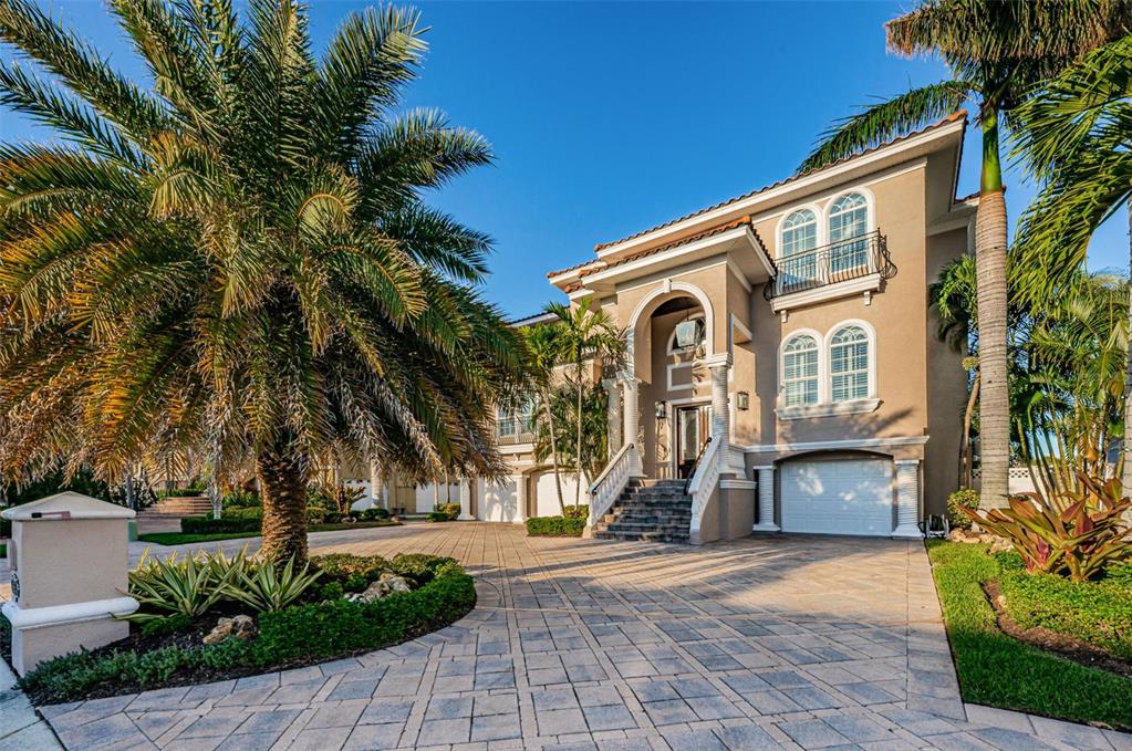 A FABULOUSLY LUXURIOUS WATERFRONT ESTATE LOCATED IN TAMPA BAY’S PREMIER GATED, BOATING & GOLF COMMUNITY! Lined with mature Royal Palms and a fine circular brick-paver driveway, towering concrete columns and cast-stone handrails/balusters introduce an impressive 18ft-high, covered double door entry. Polished travertine & hardwood floors and splendid wood finishes open to a soaring 20ft-high great room with rich cast stone gas fireplace - all overlooking the waterfront. Superb dining area, offering the right balance of elegance & intimacy, boasts a striking saltwater aquarium and exquisite pass-thru serving buffet. A dazzling gourmet chef’s kitchen features casual waterfront dining, stunning Carrera Quartz counters, custom coastal white cabinetry, Subzero/Wolf Appliances, gas cooking, center island prep/beverage center, dedicated work desk and a multi-level breakfast bar! Your waterfront den includes a wonderful wetbar with gorgeous quartz counters & exceptional cabinetry. Step out to the well-appointed, 27ft-wide family balcony and take-in beautiful views of your pool deck and waterfront. 1st living level area includes a terrific guest bedroom suite, a separate office with closet (5th bedroom) and an adjacent full guest bath. The opulent 3-stop elevator opens to a large 3rd level sitting area/loft. Graceful double doors open to the magnificent, water-facing owner’s suite, with multi-level ceilings, private access to covered waterfront balcony, and generously-sized closet with separate his/her closet systems. Looking out to the water, the owner’s bath is posh and pampering – with quartz vanities, dedicated cosmetics center & large walk-in shower with dual showerheads – all brilliantly finished in polished travertine. 2nd and 3rd upper level bedrooms are ensuite, with lovely baths and attractive walk-in closets (2nd bedroom overlooks the water, opens to balcony). Your lower level garage transitions to one of the finest waterfront entertainment spaces you will find anywhere. There is a 2020 22 KW whole house generator with 500 gal propane tank. Gorgeous covered built-in outdoor SS kitchen is complemented by lavish granite/tile/wood finishes thru-out, all protected by electronic storm shutters. Area contains a large bar & several dining/lounging areas. Beyond the brick-paver pool/spa deck rest the durable Ipe Wood dock & 13K lb boat lift - providing easy access to Boca Ciega Bay. An outstanding luxury value with wine room, extensive storage & long list of amenities! Dimensions are estimates, buyer to verify dimensions.