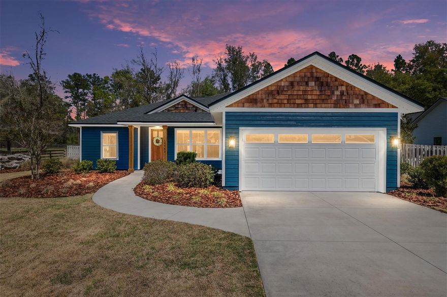 Newer Construction. This 1702 square foot home for sale under $400K in gated Peyton’s Preserve in Alachua Fl with ½ acre fenced lot and easy access to Gainesville, High Springs, and Lake City. Built in 2020 by Golden Hammer Construction, this 4 bedroom, 2 bathroom home offers a desirable open floor plan, modern finishes, and privacy on a spacious 0.5 acre lot in one of Alachua County’s sought-after gated communities.
Located at 19780 NW 159th Place in Alachua, FL, this home provides a balance of quiet residential living with convenient access to US-441, I-75, Gainesville, and surrounding North Florida destinations. The property is approximately 15–20 minutes to Gainesville, 20–25 minutes to Lake City, 10–15 minutes to downtown Alachua, and just 15 minutes to High Springs and its popular natural springs, parks, and outdoor recreation areas. Nearby Publix, Lowe’s, restaurants, and shopping along US-441 are also just minutes away. Inside, the home features a two-way split bedroom floor plan with 4 spacious bedrooms and 2 full bathrooms, offering both functionality and flexibility. The open concept living area is filled with natural light and enhanced by high ceilings, tray ceilings in the great room and primary suite, and LED lighting throughout. Durable luxury vinyl plank flooring runs through the main living areas, providing both style and easy maintenance. The kitchen is designed for everyday living and entertaining, featuring granite countertops, solid wood cabinets with soft-close doors and drawers, a walk-in pantry, and ample counter space. French doors add natural light and connect interior living to outdoor spaces. The primary suite includes a tray ceiling, walk-in closet, and comfortable layout, while the additional bedrooms are generously sized. A separate indoor laundry room with utility sink cabinet vanity adds convenience, with washer and dryer negotiable. Exterior features include Hardie board siding with frame construction and double insulated vinyl windows, offering durability and energy efficiency. The home sits on a private, fully wood-fenced ½ acre lot with front and back irrigation, creating a functional outdoor space for a variety of uses. Enjoy both a large covered front porch and a spacious covered back porch, ideal for relaxing or entertaining. The backyard also includes a large storage shed and playset, adding even more versatility.