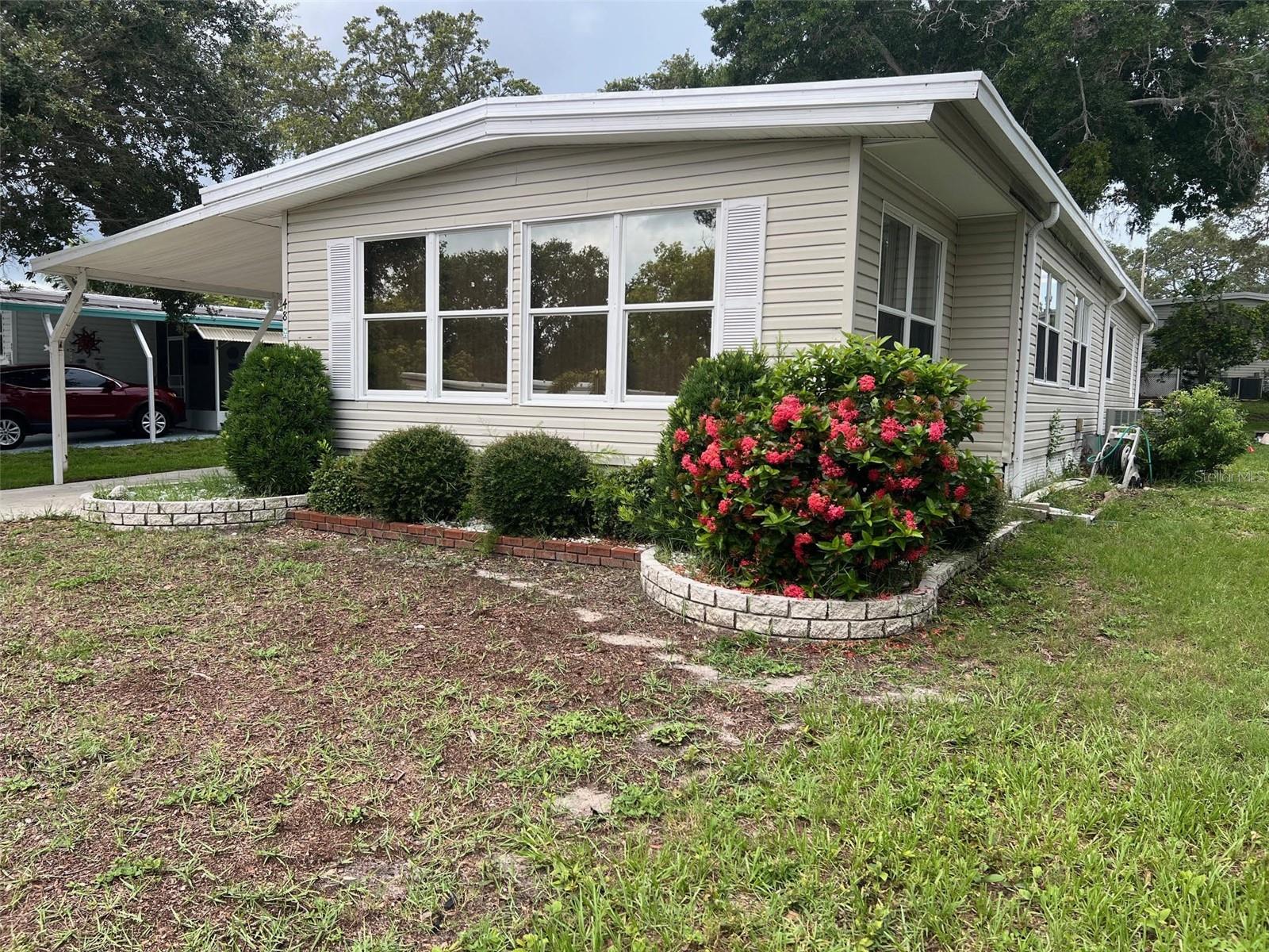 This new-to-the-market home is located in one of the most popular sections in the 55+ community of Palm Hill Country Club, which is, the "Forest Section". The tree-lined winding streets make this a charming area. You are off the beaten path but still have access to all of the activities and amenities that are offered. For a very low cost of only $554.00 per month you can live very comfortably and still enjoy this resort-style community. Included in the fee is the water, sewer, lawn, garbage, cable,and internet...what a fabulous deal!INTERIOR:
WOW...This home is huge...The 1440 square feet is one of the largest homes in the park. The dining/living and front rooms are massive and have an abundance of space for when the family visits. No need for a hotel as the 2-bedroom, 2-bath home can accommodate a large group of people. Entertaining is also effortless and friends can all congregate in the open and spacious living areas. The kitchen has a convenient breakfast bar, all necessary appliances and lots of storage space. If extra is needed the dining area has a wall-to-wall china cabinet with more than enough cupboard space. Both bedrooms are considerable sizes and have built-in dressers and walk-in closets. The guest bath has shower and tub combination with the master having an en suite bath with a separate vanity from the walk-in shower and toilet. One major valuable feature of the home would be that all of the subfloors have been replaced with 3/4 inch plywood. New vinyl flooring and berber carpet are the floor coverings. The windows are newer and flow throughout the home. The ceiling fans and ceiling duct work are definitely favorable features and for your convenience, the home will remain fully furnished and equipped.EXTERIOR:This lovely home is situated away from the street for privacy and provides a long driveway for two cars. Lush landscaping encompasses the home and the screened porch has a cozy atmosphere. The shed is within this area and has a washer, dryer and extra refrigerator. A roof over, vinyl siding, a newer A/C unit and again the stunning location make up the exterior of the home. Call today for a private showing...this one will not last!