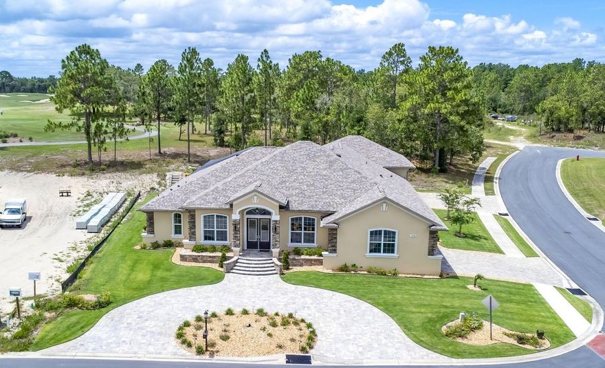 5 Bedroom Custom Home | Boat & RV Garage | Outdoor Kitchen | Top-Rated Golf Course Views | Gated Community Welcome to this exceptional CUSTOM-BUILT Curington home situated on a premium corner lot in the gated golf course community of Juliette Falls. A circular paver driveway and grand entrance create an impressive first impression. Car and recreation enthusiasts will appreciate the DOUBLE GARAGE SETUP, including a front garage for two vehicles plus a golf cart and a massive 36-foot-deep rear garage with 12-foot doors, ideal for boats, RVs, or additional storage. Both garages and lanai feature durable epoxy flooring. The OUTDOOR LIVING AREA is designed for entertaining and relaxation, featuring a dramatic two-story screened enclosure, a relaxing spool with illuminated waterfall, and an entertaining deck overlooking holes 1–4 of the golf course. The covered lanai includes seating and dining areas, a six-person Master Spa HOT TUB, and a fully equipped OUTDOOR KITCHEN with built-in griddle, searing stations, sink, prep space, granite counters, and bar seating for six. There is also ample space to add a full-size pool if desired. INSIDE, soaring ceilings, 8-foot doors, crown molding, and a modern open split-floor plan create a spacious and elegant atmosphere. The home offers five bedrooms and three full bathrooms. The FORMAL DINING ROOM showcases a coffered ceiling with accent lighting, chandelier, built-in hutch, recessed niche, and quartz serving bar. The GOURMET KITCHEN features an oversized and elevated island with Alaskan granite, seating for four, abundant cabinetry, whquartz countertops, farmhouse sink, beverage refrigerator, walkin pantry, and premium stainless appliances including a wall oven, microwave, induction cooktop, decorative hood, and LG French-door refrigerator. A built-in desk and corner WET BAR with lanai access make entertaining effortless. The expansive GREAT ROOM centers around a modern linear fireplace and 82-inch TV feature wall with built-in bench seating, floating shelves, and coffered ceiling. Triple pocket sliders open seamlessly to the lanai for true indoor-outdoor living. The luxurious PRIMARY SUITE offers a private sitting area, coffered ceiling, dual custom walk-in closets, and a spa-inspired bath with dual vanities, floor-to-ceiling tiled shower, dual shower heads, dual built-in niches, and transom window. Three ADDITIONAL BEDROOMS are located in a separate wing, including a Jack-and-Jill layout and guest bath. A fifth bedroom or den at the front of the home provides flexibility for guests or office space. Numerous FEATURES include a well-equipped laundry room, two tankless water heaters, dual HVAC systems with three zones, whole-house water filtration, public utilities, and a separate irrigation well with Wi-Fi-enabled sprinkler system. Luxury vinyl plank flooring runs throughout the home, with tile in wet areas. Located near Rainbow Springs State Park and convenient to shopping, dining, healthcare, and the World Equestrian Center, this home offers upscale living within two hours of both Tampa and Orlando and about 30 minutes from Florida’s Gulf Coast.