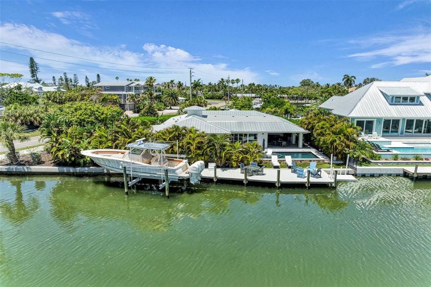 Welcome to 501 68th Street, located in the heart of Holmes Beach on beautiful Anna Maria Island. This exceptional waterfront home on the Grand Canal offers the ultimate island lifestyle—boating, sunshine, and world-class beaches just moments away.

This 4-bedroom, 3-bath coastal retreat features deep water access to Tampa Bay and the Gulf of Mexico and is offered furnished with a few exceptions. Southern exposure and lush landscaping create a private tropical setting with a mango tree and fenced backyard.

Designed for resort-style living, enjoy a heated pool, oversized spa, and 12x60 dock with 20,000 lb lift. Extensive 2021 upgrades include a new roof, impact windows and sliders, and updated dock and pilings.

Inside, white oak hardwood-look plank tile flows throughout. Two walls of impact sliders open to the water, while the family room offers a custom bar and vaulted tongue-and-groove ceilings. The chef’s kitchen is sure to please with quartz countertops, custom built-ins with appliance garages, a large island, and high-end appliances including a Fisher & Paykel stove and Bosch refrigerator.

The layout includes two guest bedrooms, a hidden laundry room, and a private primary suite with walk-in closet, water closet, and sliders to a secluded turf area by the pool. A flexible den serves as a fourth bedroom or guest space.

Enjoy the covered lanai overlooking the Grand Canal, pre-plumbed and wired for a future outdoor kitchen—perfect for entertaining.

Additional highlights include a 2025-installed 26KW whole-house generator with a 500-gallon propane tank, oversized garage, carport, and ample parking.

A rare opportunity to own a deep canal waterfront home in one of Anna Maria Island’s most desirable boating locations.** Property information received from third-party sources is considered reliable but is not guaranteed.  All information should be independently verified by buyers and buyer's agent.