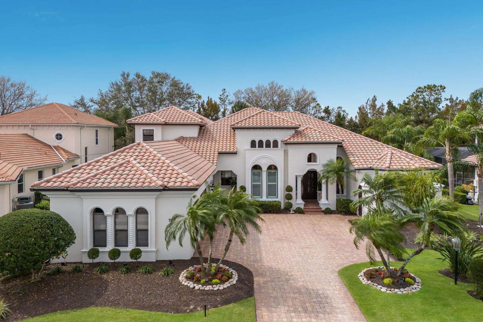 The ultimate tropical oasis setting, this elegantly appointed two-story residence in Lakewood Ranch Country Club exudes a swoon-worthy and private resort feel . The expanded Ballina by John Cannon Homes encompasses 4,487 square feet of generously proportioned living spaces, soaring ceilings, architectural detailing, just PAINTED INSIDE and OUT, and an an expansive outdoor retreat with extensive open and under cover spaces, full summer kitchen with new 2024 grill, heated pool/spa and updated landscaping.
Live and entertain flawlessly in this two-story just painted and impeccably maintained and updated throughout exuding a classic elegance where there is no shortage of living well. Beyond the hurricane impact iron entry doors reveals the grandly-sized living room with floor-to-ceiling aquarium windows just off the formal dining area juxtapose a wet bar with NEW thermostat controlled GE Monogram WINE REFRIGERATOR, sink, stone counters and wood cabinetry.
Meanwhile the epicenter of the home is the family gathering room boasting a gas fireplace and disappearing cornerless sliding glass walls that brings the outdoor living area in seamlessly incorporating the breakfast area and gourmand’s well-appointed kitchen with All NEW 2024 GE MONOGRAM APPLIANCES, wood cabinetry, ample granite and quartz counters, and an oversized walk-in pantry. The residence also features a designated office on the main level that offers built-in bookshelves, soaring ceilings and wood flooring.
Relax and unwind in the elegant owner’s retreat positioned on its own private wing on the main level with direct lanai access, elevated sitting area, two customized walk-in closets, and a luxuriously appointed spa-like bath with separate vanity stations, dual entry shower, and a separate soaking tub. Guests will appreciate two generous suites on the main level, each with access to their own full bath and walk-in closets. The home’s fourth guest suite and fourth full bath resides on the upper level, as does the expansive bonus room with screened terrace with all new aluminum railings and screens. This bonus room offers flexible living options as a theater, game room, secondary office or potential 5th guest suite.
Positioned within the luxury enclave of Legends Walk, there are numerous appointments that highlight this magnificent Country Club residence, some of which include newly installed AC units in 2021, impact double iron front doors in 2022, hot water heater in 2021, new pool heater in 2023, Sonos sound system inside and outside updated in 2022, landscape lighting updated in 2021, refurbished sprinkler system in 2022, laundry room with ample cabinetry, sink and newer washer/dryer, interior paint completed in 2024, exterior painted in 2024, and a courtyard side-load 3 car garage with Garage Tek storage cabinets, and epoxy flooring in 2024.
Non-mandatory membership opportunities to become a member of Lakewood Ranch Golf & Country Club are possible, which includes a state-of-the-art Fitness center, Clubhouses, junior Olympic-sized pool, four 18-hole championship golf courses, Tennis, Pickleball and more. Lakewood Ranch is the #1 top-selling master-planned community in the country with shopping, dining, A-rated schools, and, of course, Sarasota’s renowned beaches.