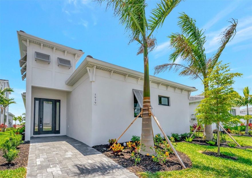 One or more photo(s) has been virtually staged. BRAND NEW CONSTRUCTION in the gated community by Medallion Homes, AQUA. Situated near the Sarasota Bay this new community is highlighted by a four-acre translucent, blue lagoon and tropical shore providing a luxurious beach in your own backyard. This stunning open floor plan home features 3 bedrooms, 2 baths, private courtyard with pool/spa combo and tile flooring throughout. Enjoy the unobstructed water view from your front entrance, as this premium lot has no home situated directly in front of it. 
As you step into the home you will immediately feel the sense of how methodically the homeowner’s custom designed this space throughout.  With no expense spared, nearly $300k of upgrades were invested into this popular Safrron Plum floorplan to create a peaceful retreat and entertainer’s dream, while still carefully considering important conveniences to everyday life. The living room features a trey ceiling and is highlighted by an electric fireplace with color changing features and a floor-to-ceiling shiplap accent wall.  Just off the living room is the fully customized gourmet chef’s kitchen which includes an enlarged island, an upgraded cast iron farmhouse sink, upgraded quartz countertops, waterfall edges, extended cabinetry to the ceiling with crown molding, and an oversized range hood. 
All appliances have been upgraded including a Sub Zero refrigerator, Wolf gas cooktop and electric oven, built-in Sharp microwave, and Décor dishwasher. The full dry bar with quartz backsplash to the ceiling includes a Sub Zero ice maker and Kitchen Aid beverage refrigerator. There is a full walk-in pantry with custom built-in shelving adjacent to the dry bar. Just off the kitchen is a large dining room that could easily be used as an entertainment space with a pool table as well. 
Conveniently situated in the middle of the home is a private courtyard that includes a heated pool/spa combo with a waterfall, jets, oversized tanning shelf and LED lights to create a relaxing home oasis when you don’t feel like going to the lagoon. There is also a covered lanai with a custom electric awning to provide shade off the dining room as well as natural gas hookup to create your outdoor kitchen and entertainment space. Off the courtyard is direct access to the master bedroom with trey ceilings.
In the bedroom you will find a walk-in closet with all custom built-ins, a double vanity sink, and spa-like extended shower with seating, body sprayers, and multiple shower heads. A second bedroom sits off the main entryway and is currently setup as an office/den. The third bedroom sits on the other end of the home with custom built-ins for the closet and is located next to a beautiful full 2nd bathroom with a shower. Just off the 2nd bathroom is a full laundry room with cabinet storage and an added sink. 
Garage entry is to the rear of the home with a paver driveway and includes a two-car garage with epoxy flooring, luggage shelving, and a side service door. Electrical upgrades were installed throughout the home to include wiring for AV and cameras. This Florida paradise is conveniently located near world renown IMG Academy, IMG Golf & CC, Anna Maria Island, Cortez Village, and SRQ airport, while remaining a short drive away from shopping and entertainment districts such as UTC and St Armand’s Circle. Beat the wait for a new build and schedule your private showing of this fully completed TROPICAL PARADISE!!