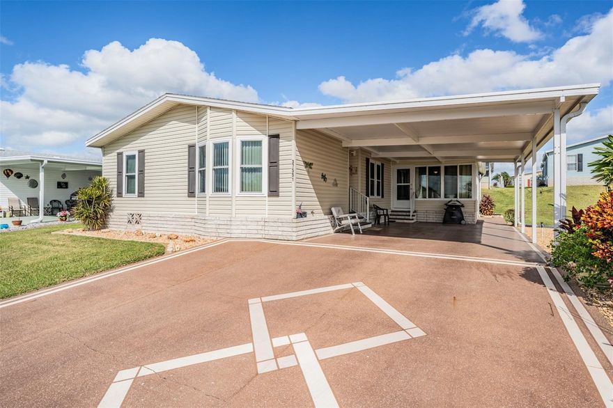 GRAND HORIZONS, where you OWN your Land in this Premier 55+ GATED Community in Sunny Florida IS the place to BE!  Drive your Golf Cart on the Private streets and Enjoy Resident Owned Amenities including Clubhouse with Commercial kitchen, Billiards room, Library with games, puzzles and wifi, Craft room, Shuffleboard, Heated pool and hot tub, planned activities, dinners, onsite entertainment and travel excursions in this well maintained neighborhood!  Eye catching Rock Landscaped beds all the way around the home and custom Painted driveway with design welcomes you with plenty of room to park several vehicles with extended parking pad.  Once inside, notice the durable, waterproof and stunning Luxury Vinyl floors ($8,000) in the common areas.  Front room with bay window overlooks the lawn and is Light, Bright and Inviting!  This flex space can be a Formal dining room or Living room with secondary bedrooms (one set up as a guest bedroom and the other a home office) with guest bath off this wing.  Kitchen is the HUB of the home with High breakfast bar, tile band, etched glass cabinet doors, wood cabinets, white appliances and eat in dinette area.  Sliding doors to enclosed Florida room with slider windows and access to the carport to bring in those groceries!  OWNERS retreat is SPACIOUS and just off the leisure room.  Bath ensuite has raised vanity with dual sinks, wood cabinets with 6 drawers and shower with seat.  This ONE OWNER home has only been used 1/2 the year as a Snowbird haven 6 months out of the year and has been updated with NEW Shingle ROOF 2019 on the main house and Insulated Rubber Roof Over Carport and enclosed Lanai! $8,000 Double pane, insulated windows tilt in to clean and help with energy efficiency along with the NEW Carrier AC in March 2022 with heatstrip and a 10 year transferrable parts warranty.  Washer and Dryer were replaced 2020, Range and Microwave 2023.  Shed is attached and has loads of sturdy shelves for storage and a workbench.  Furniture is Negotiable and Owner will consider Seller Financing with large downpayment.  GREAT LOCATION within one mile of shopping, restaurants, theater, bowling, wellness center, YMCA, doctors, hospital, medical facilities and major highways US 301 and I 75 for easy commute to Wesley Chapel, Lakeland, Tampa, Ocala, Orlando, International airports and the Beaches!  CALL TODAY!