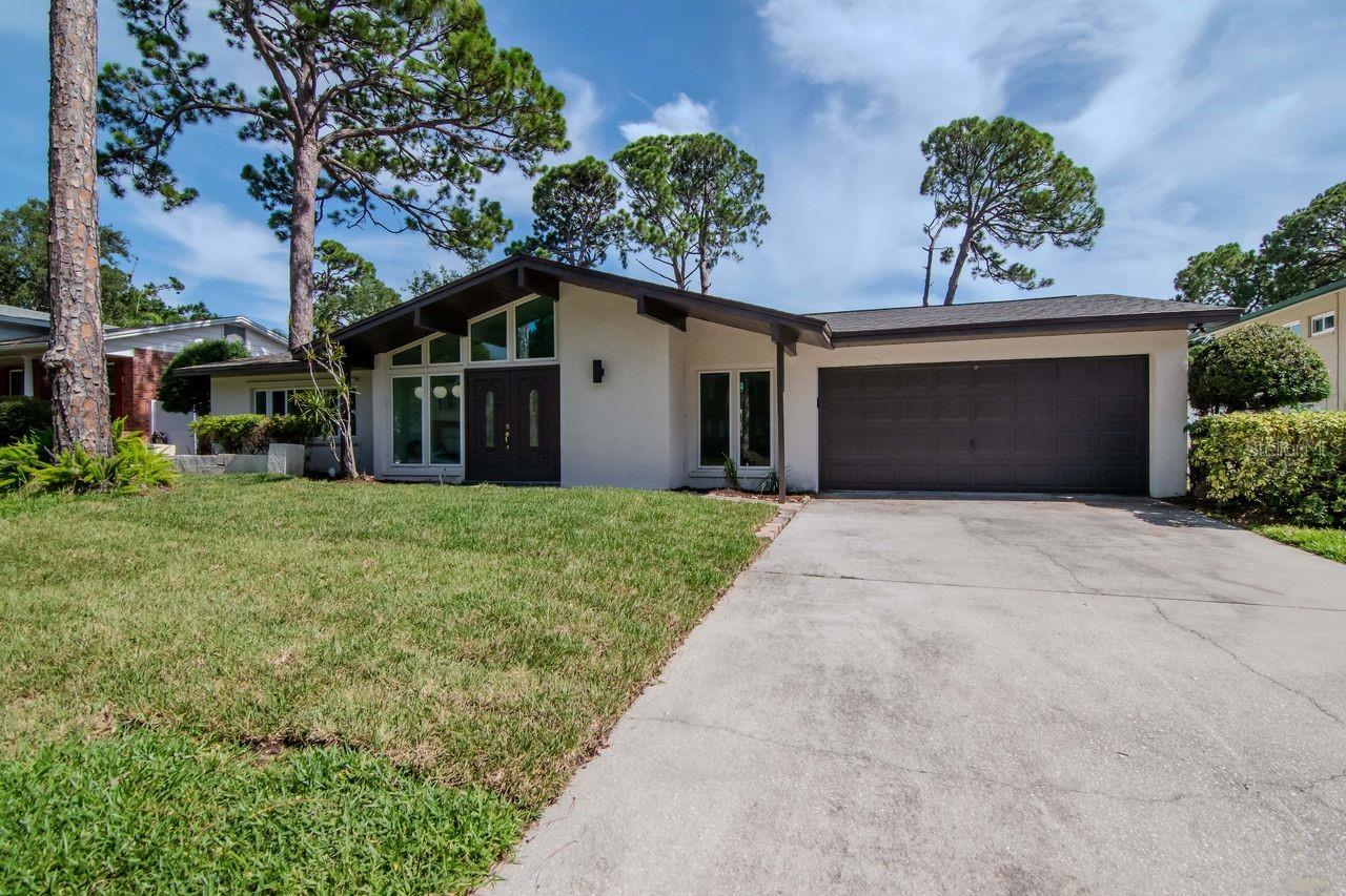 With a nod to mid-century architecture, this light, airy large home was built by Avanzini Builders and is being brought to the market for the first time in many years. This beautiful home is located in the highly sought-after Whispering Pines Subdivision and is located in flood zone X. It is conveniently located just 2 miles from Gulf beaches and 1 mile from top-rated Elementary, Middle and High Schools, grocery stores, pharmacies, restaurants and gas stations. The property is also located 3 miles from Seminole City Center, which offers a variety of stores, restaurants, movies and fitness center. This stunning home boasts 5 generous bedrooms and 3 full bathrooms, wood-burning fireplace, laundry room and high vaulted ceilings, in nearly 3,000 square feet of living area, and a two-car garage. It is bathed in natural light from large vinyl double-pane impact windows in every room. As you enter, you are greeted by the tremendous living room/entertainment space. The centrally located kitchen/bar seating area is open to a massive Great Room, which is perfect for entertaining. They seamlessly connect with the living and dining areas. Behind the Great Room is the Florida Room with a wood-burning fireplace, which overlooks the garden and extended patio. The large back yard is big enough to accommodate a swimming pool and spa. This home has a new shingle roof (2025), new flooring (2025), and has been freshly painted (2025). This property offers the perfect blend of comfort, style and functionality. It could also be an excellent investment property with a layout that inspires a number of possibilities. A one-story home of this size, in this location, does not come on to market often. Must see!