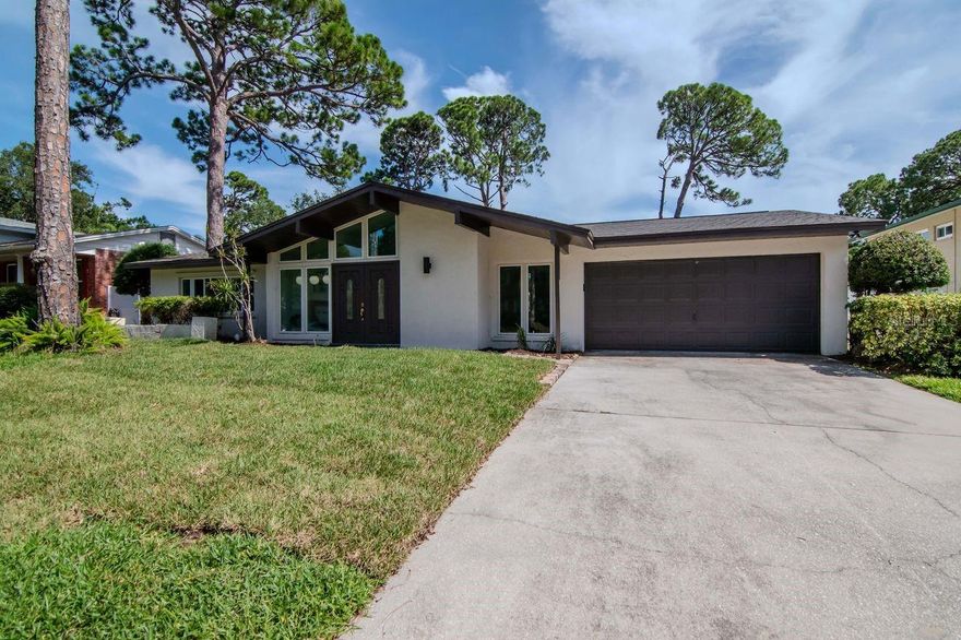Location! Location! Location! FLOOD ZONE X!!!! 1 mile from Highly Regarded Schools, 2 miles from the Gulf Beaches! NEW ROOF (2025), NEW FLOORS (2025), FRESH PAINT (2025) throughout. 5 Generous Bedrooms, with 3 Bathrooms. Just under 3000 Square Feet, all on a Single Story! With the ideal combination of mid-century architecture and modern conveniences, this light, airy, large home was built by Avanzini Builders and is being brought to the market for the first time in many years. This exquisite home is located in the highly sought-after Whispering Pines Subdivision and offers the perfect blend of comfort, style, and functionality. Light and Open Living Area with high vaulted ceilings seamlessly connect to the kitchen and dining areas, making this home perfect for entertaining. External windows have been upgraded to Double-paned Impact Glass, with additional Hurricane shutters for extra protection. Bright and airy Florida room with working wood burning fireplace, overlooks the garden and extended patio! Oversized 80’x120’ Lot has enough room for a pool, while still having plenty of yard. A one-story home of this size with a large 2 car garage, in this location, does not come on to market often!