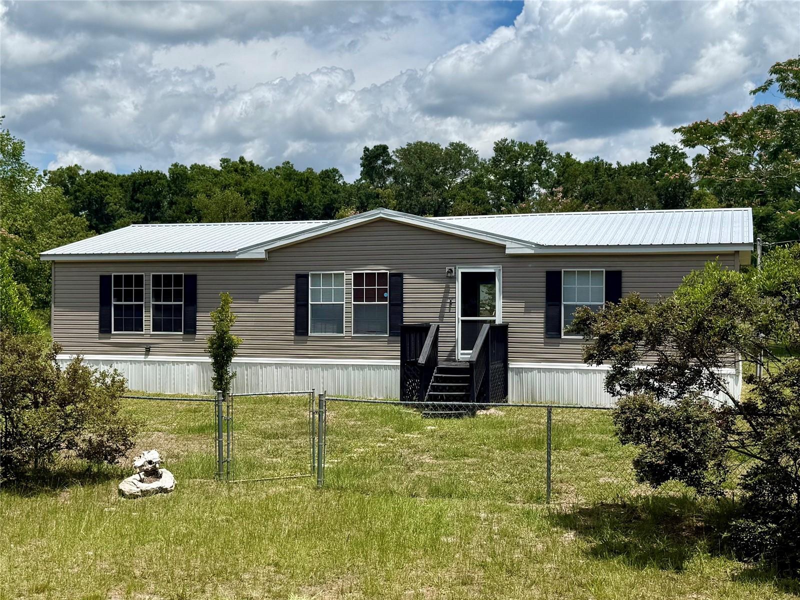 100% USDA Financing elligible!
3-Bedroom Home on 1.52 Acres – Move-In Ready!
Peace and quiet in the country, but less than 15 minutes from Publix, Celebration Pointe, and Butler Town Center, and only 20 minutes from UF, Shands, and the VA!
Discover the perfect blend of comfort and space with this 3-bedroom, 2-bathroom manufactured home, built in 2005. Nestled on a 1.52-acre lot, this property offers plenty of space without too much yard work. The fully fenced back yard is perfect for animals, gardening, or entertaining.
Step inside to an inviting split floor plan with stylish luxury vinyl plank flooring throughout, combining durability with modern appeal. The open floor plan seamlessly connects the kitchen, dining, and living spaces, making it ideal for gatherings or cozy nights in. The spacious primary suite includes a private en-suite bath with dual vanities and separate tub and shower, while two additional bedrooms and a second full bath provide flexible space for guests, a home office, or a creative studio.
Enjoy durability and peace of mind with a metal roof, ensuring longevity and low maintenance. Whether you're looking for a peaceful retreat or a home with plenty of room to grow, this property is a must-see!
Schedule your showing today and experience country living with modern convenience!