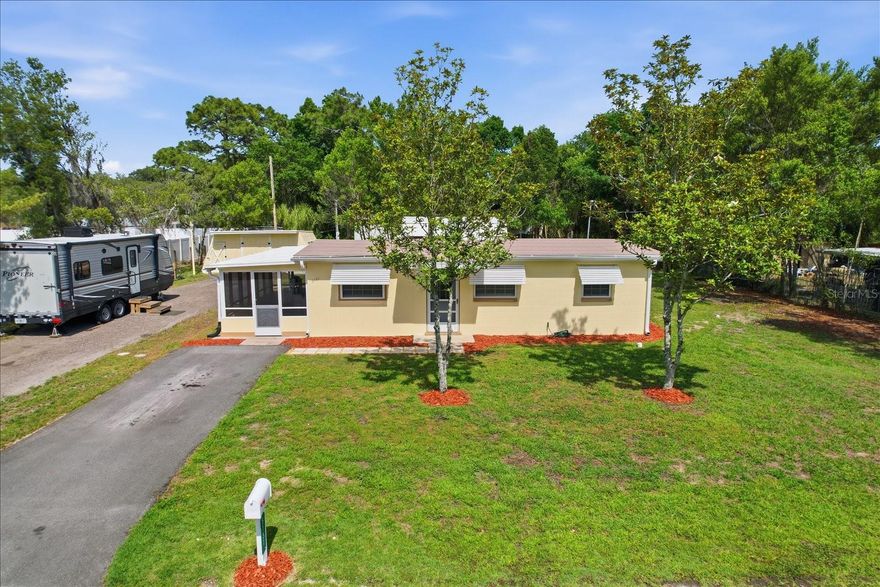 Charming and versatile property offering strong investment potential or an ideal primary residence. Recently updated, this home features fresh interior and exterior paint and is move-in ready. The layout includes 1 bedroom and 1 bathroom, with additional space that could be utilized as a second bedroom, plus a bonus room for added flexibility. The updated bathroom includes a jetted tub. Exterior features add significant value, including a screened-in lanai, a detached shed with a tiny home-style appearance, and a separate utility building designed like a small barn with an attached greenhouse. The property is equipped with a permanent RV pad with water, electric (30 amp), and sewer hookups, with space to accommodate up to two RVs. A 90-foot driveway provides ample parking. Recent improvements include a new roof, upgraded electrical system, mini-split AC unit, and tankless water heater. The septic system has been recently inspected and approved (January 2026). The utility/barn structure has also been updated with a newer roof and flooring.