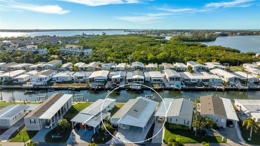 Welcome to easy waterfront living in this fully turnkey furnished 2 bedroom, 2 bathroom manufactured home located in Tropic Isles Mobile Home Estates, a 55+ community where you own the land. A brand new roof adds peace of mind, and the waterfront setting offers direct access to Terra Ceia Bay and the Gulf, making this an ideal opportunity to step right into the Florida lifestyle. A boat and a brand new golf cart are available for purchase, negotiable with the sale. Step inside to a bright and open interior featuring a recently remodeled kitchen with white cabinetry, stainless steel appliances, a large center island with seating, and generous storage. The kitchen flows naturally into the dining area and living space, creating a comfortable and welcoming environment for everyday living and entertaining. Large windows throughout the home allow natural light to fill the space and enhance the coastal feel. The living room opens directly to the front Florida room, offering a versatile space that’s perfect for morning coffee, reading, or hosting guests. At the rear of the home, a separate Florida room overlooks the water and is accessed from the exterior, providing a peaceful retreat ideal for relaxing and taking in the waterfront views. Outdoor living truly shines here. The private dock and boat lift, built in 2017, include water, electricity, and a fish cleaning station, making it easy to enjoy days on the water. The spacious driveway allows for extra vehicle parking, and a separate workshop with electricity located in the carport offers excellent space for hobbies, storage, or projects. The land is owned by the homeowner, with a $50 annual HOA for deed restrictions. Whether you’re looking for a full-time residence, a seasonal retreat, or a peaceful waterfront escape with quick Gulf access, this inviting home offers a wonderful opportunity to enjoy life on the water in a sought-after 55+ boating community.  **THIS PROPERTY QUALIFIES FOR A 1% LENDER INCENTIVE IF USING PREFERRED LENDER. INQUIRE FOR MORE DETAILS.**