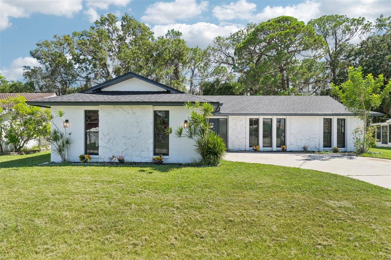 One or more photo(s) has been virtually staged. Step right into your dream life in this warm and welcoming waterfront community gem. Picture yourself on brand-new LVP floors, wandering through sunlit spaces flooded with natural light. The freshly painted rooms—both inside and out—feel sparkly and new. The remodeled kitchen with Calcutta gold quartz counters and a charming breakfast bar looks over the family room, where soaring ceilings and woodland views make every morning feel like a little adventure.
The home was thoughtfully updated, with new doors, impact windows, totally redone baths, new HVAC, and a brand-new roof in 2025, over $100k in updates—so you can move in and relax. The split-bedroom layout gives everyone their own space, including a primary suite with a private bath and a third room that adds even more flexibility. Plus, there's an inside laundry, a covered porch, and a two-car garage that make daily routines a breeze.
Step outside and you’re greeted by your own backyard escape—wooded, peaceful, perfect for lazy mornings or evening chats under the porch. And when you’re ready to play, your optional HOA opens the gate to your private beach: swim in the Gulf, lounge on the sand, picnic in pavilions, and stroll along the beach, feeling secure as it is a gated and private area. With quick access to U.S. 19, local shops, restaurants, Tarpon Springs Sponge Docks, Fred Howard Park, and only 30–45 minutes from Tampa International, Busch Gardens, or theater outings—and just about 1½ hours to Disney—this home is more than four walls. It’s a lifestyle. Be sure to schedule your showing today!