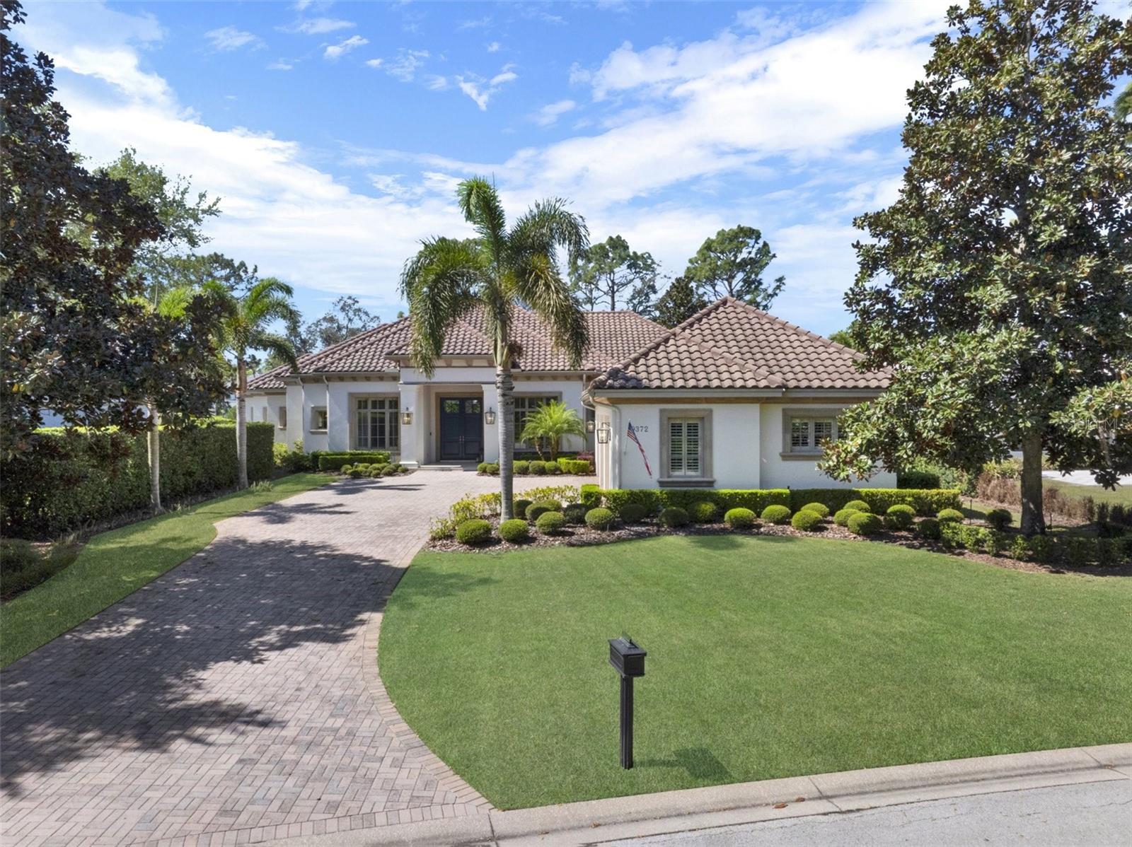 Privacy, Outdoor Living at its finest, One-Level, Open, Split Floor Plan, Incredible Flow, Tremendous Natural Light, Water & Conservation views, these are a few of the wonderful characteristics of this beautiful, custom-built estate by Maroon Fine Homes in 2009. This meticulously maintained home features almost 5,200 SF of living space, 4 bedrooms, 4.5 Baths, a Dedicated Office, Bonus/Game Room with Wet Bar, 3-Car Garage, a plethora of outdoor living space, and Private Pool & Spa, all situated on nearly 0.5 acres on a double-ended cul-de-sac street. Enjoy the Mediterranean style as you pull up the front paver driveway and see the stone-wrapped columns at the front entry, clay barrel tile roof and mature, lush landscaping. Everyone will be impressed when entering the double, front doors and see straight through the huge pocket glass sliding doors to a beautiful pool & spa. The incredible outdoor oasis features 1,259 SF of covered, screened-in living, a gas fireplace, Summer Kitchen and numerous areas for relaxing, entertaining and watching stunning sunsets over the glistening pond. This split plan offers the perfect layout, on one side of the home there is the primary suite, an office, secondary bedroom and the powder bath. On the other side are two bedrooms with en-suites and laundry and in the back is the open concept kitchen, living area with bonus room! The oversized primary retreat is serene and tranquil with views of the pool and its own private access to a covered area. It also features a sitting area, a built-in dry bar with an undercounter refrigerator, gorgeous ceiling trim detail, a huge closet with custom built-ins and its own washer and dryer for convenience. The oversized primary bath has separate vanities, a beautiful built-in tub with pond views and a large shower adorned with gorgeous accent tiles throughout, beautiful custom light fixtures and wallpaper! The half bath has a custom vanity with stunning tiles and accent lights, which also has access out to the pool oasis. The second bedroom with private en-suite has views of the front yard. The dining room opens to a wet bar and features an exquisite chandelier, highlighted by the unique ceiling details. Beyond the bar is the kitchen, family room and eat-in kitchen area, that flow seamlessly, perfect for entertaining. The gourmet kitchen features a large bar offering tons of seating areas. There is also an oversized island with a gorgeous linear chandelier. The top of the line, built in appliances and custom floor to ceiling elegant cabinets create a beautiful and practical space for any chef. Additionally, there is a hidden pantry. The family room has a beautiful built-in wall unit for the TV and audio equipment. The ceiling also features a one-of-a-kind detail showing off the high ceilings. Beyond the family room is the bonus room with beautiful, coffered ceilings and a wet bar. This room has sliding doors with access to the summer kitchen and pool area. There is tremendous natural light offered by a huge window overlooking the beautiful landscaping and pond.This exclusively private, 24 hour guard-gated, renowned Lake Nona Golf & Country Club home offers more than just a lovely home…it offers a “lifestyle;” one filled with family, friends, golf, lake living and privacy. All A-rated schools, within minutes of Orlando’s Intl Airport, Lake Nona’s Medical City, Boxi Park, USTA & situated between the 417 Greeneway & 528 Beachline. Don’t miss out on this unique opportunity!