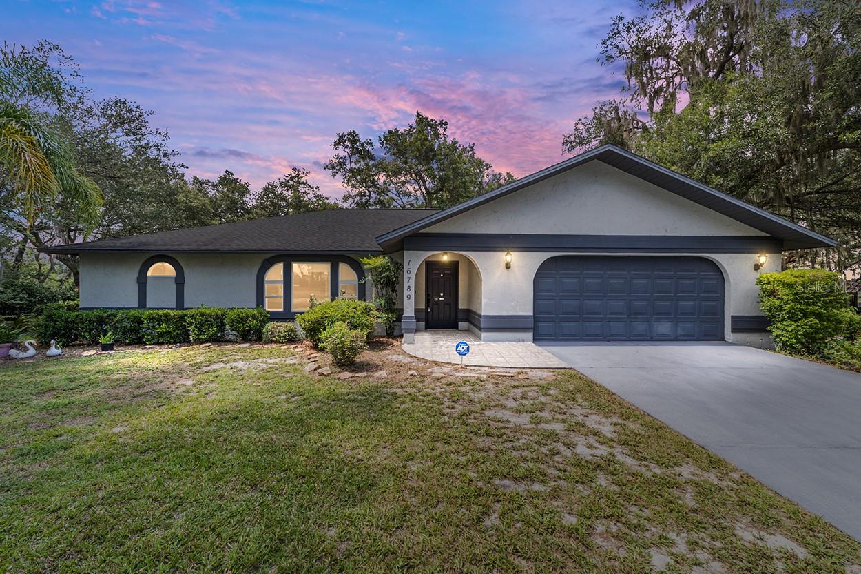 ?Welcome to your peaceful Florida retreat at 16789 SE 69th Lane in Ocklawaha—an inviting 3-bedroom, 2-bathroom waterfront home nestled on two parcels of land totaling 0.62 acres, with no HOA. Located on the edge of the Ocala National Forest, this property offers immediate access to hiking, kayaking, wildlife viewing, and so much more—perfect for outdoor enthusiasts and nature lovers alike. This beautifully maintained home features 2,106 square feet of comfortable living space with an open floor plan centered around a spacious great room with a cozy stone fireplace and abundant natural light. The enclosed Florida room offers year-round enjoyment with panoramic views of a peaceful pond, part of a quiet chain of lakes ideal for birdwatching and relaxing. The kitchen combines charm and functionality with warm wood cabinetry, a built-in oven/microwave combo, and a casual dining area. The oversized primary suite is a private haven with a whirlpool tub, tiled walk-in shower with seat, dual vanities, and a generous walk-in closet. Outside, lush landscaping and sprawling oak trees create a shady, park-like setting. Two sheds—a 9x13 and a 12x15—provide extra storage or workshop space, while zoned irrigation keeps the grounds green and thriving. Additional features include a 20KW Generac whole-house generator, roof (2017), water heater (2016), and A/C with heat pump (2018). A spacious garage adds practicality, and with no HOA, you have the freedom to make this property your own. Ideally located just a short drive to Ocala and The Villages, and only an hour from Ormond Beach and Daytona Beach, this home offers the perfect blend of comfort, privacy, and Florida’s natural beauty—whether as a full-time residence or seasonal escape.