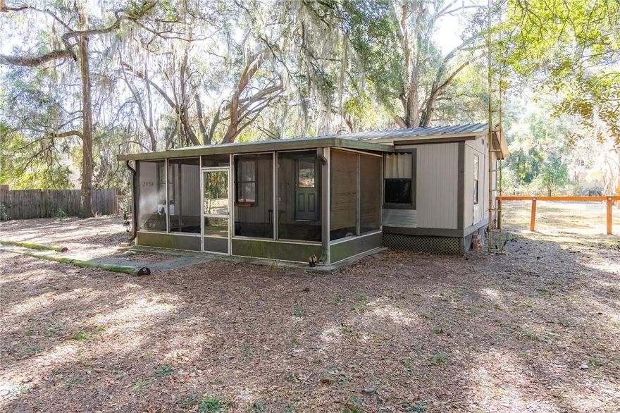 Tucked away in a peaceful Citra setting, this fully fenced 0.51 acre property features a 3 bedroom, 2 bath home with 926 sq.ft. of comfortable interior living space. The living room is centrally located and creates a practical area for everyday use. LVP flooring runs throughout the home, adding durability and easy upkeep. The kitchen opens to the main living area and features granite countertops, ample cabinet space, and room for a small dining area. The split floor plan places the primary bedroom on one side of the home, including a large walk in closet and an ensuite bathroom with a garden tub. On the opposite side of the home are two guest bedrooms, suitable for bedrooms, an office, or additional living space. A guest bathroom is conveniently located nearby and includes a shower/tub combo. Outside, the home features a screened in front porch, a fully fenced yard, and a shed in the backyard for additional storage, while still room to add a pool or additional sheds.Take the next step and schedule your private showing to explore this property for yourself!