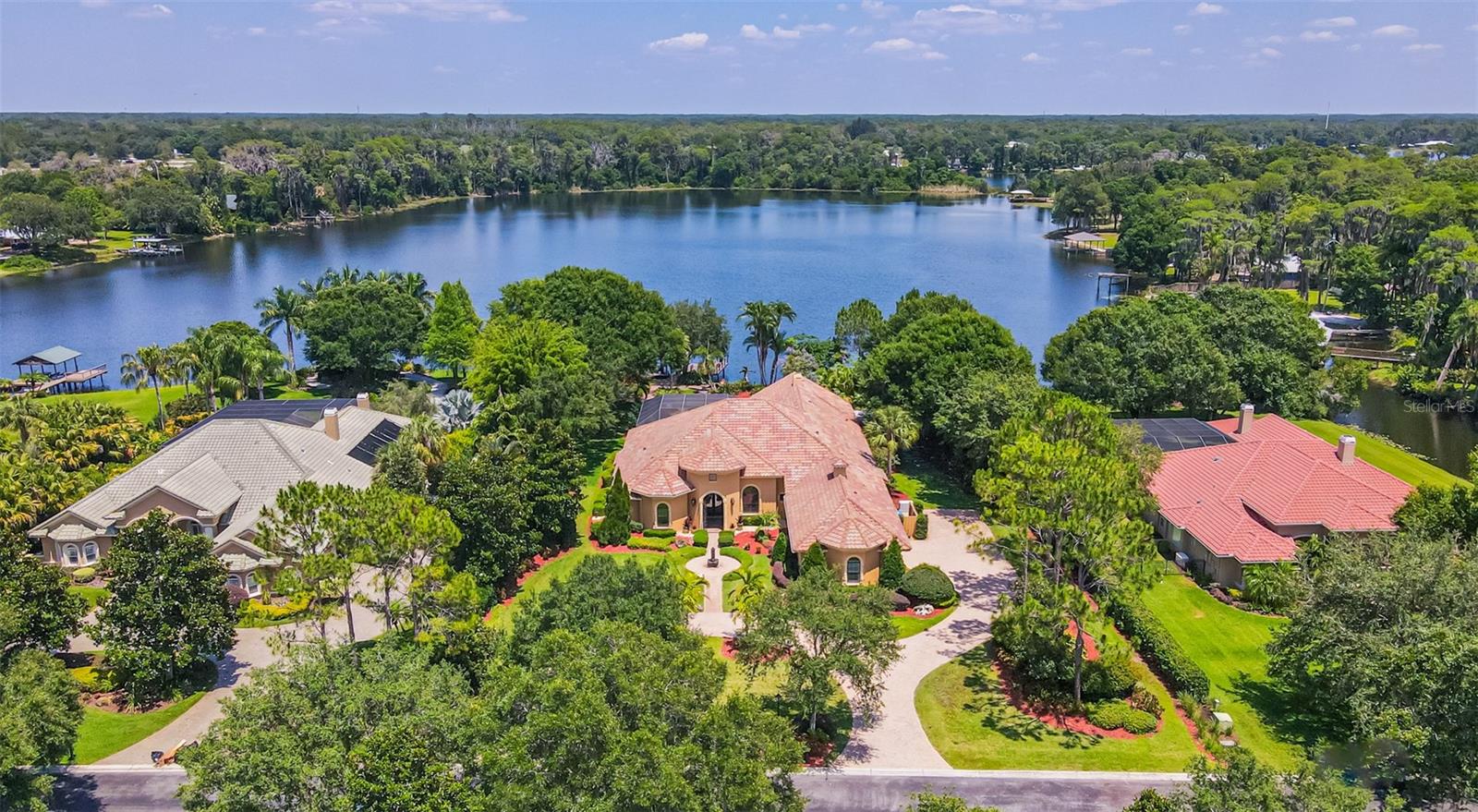 Welcome to this stunning executive home located behind the gates of Echo Lake Estates. This 4-bedroom and 3-bathroom pool home includes a den, office (with a closet) and home theater. It overlooks the glistening ski lake-Echo Lake. Echo Lake connects to the even larger Lake Church. The professionally landscaped yard sets this property apart as a slice of paradise. Year round, you can enjoy the best Florida has to offer. Outback, you will find a recently installed putting green, gas lanterns that line the pavered walk way, a fountain, a lounge space, and a gas firepit. The covered dock has plenty of room to entertain on the open deck. Upon entering the front gate of the home, you will be greeted by lavish formal dining and living rooms. Elegantly appointed with high coffered ceilings, faux paint finish, a view of the heated pool and expansive property. The eat-in kitchen is a chef’s dream with gas appliances, a walk-in pantry, belly-up bar, and a Sub-Zero refrigerator. Bring the outside in-the formal living and family rooms both offer sliding glass doors to connect with family and friends that are outside enjoying the lake views. The master bedroom is oversized. The luxurious master bath has a walk-in shower and double vanities. Soak up rest and relaxation after a long day in your garden tub. On the opposite wing of the house are the additional bedrooms. They sit just off of the kitchen and family room with one of the bedrooms making the perfect home gym! The front office is all business-but the party is in the back! The rear wing of the house is strictly for fun and entertainment with a home theater and billiards room. Recently installed in the theater is a custom Full Swing Gold Golf Simulator (purchased for $66k). The outdoor kitchen is perfect for summer parties and BBQs. Cool off in the sparking pool in the summers and warm up in the hot tub in the winters! Cozy up to the fireplace on cold winter days. Additional appointments include: recently replaced AC units, crown molding, upgraded baseboards, transom windows, tray ceilings, plantations shutters, a 3-car garage, and a circular drive. The pool motor was recently replaced along with new sod (2023). Furniture is available for purchase outside of the transaction. Pack your bags-all this home needs is you!