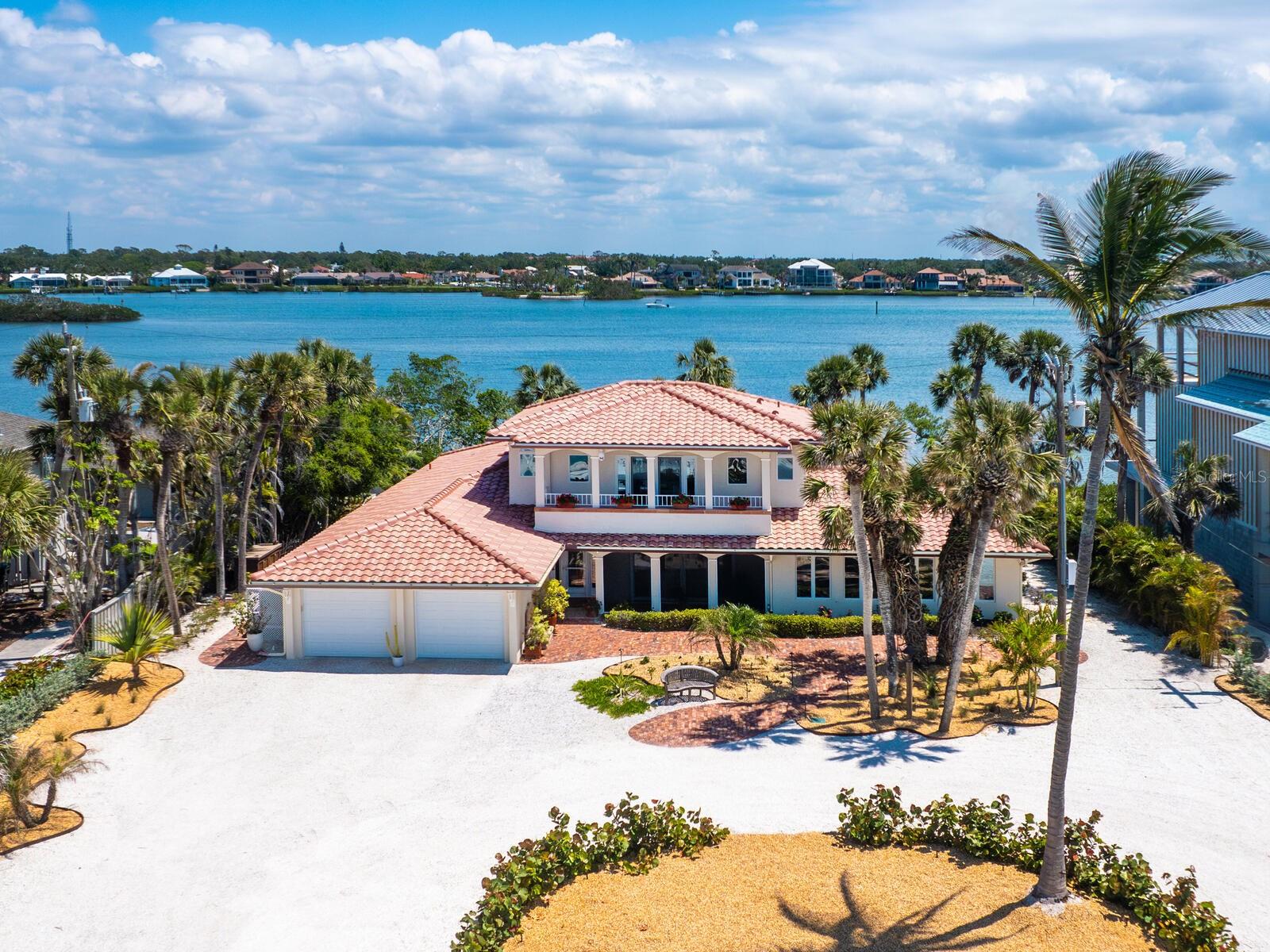 This captivating Gulf-to-Bay residence ideally embodies timeless coastal style. Start your mornings on the lanai with coffee in hand as the sun rises over the Intracoastal Waterway. Launch your boat from the bayside dock, then spend your afternoons on your private beach, where breathtaking Gulf sunsets are practically a nightly guarantee. Inside, you'll find expansive, light-filled rooms offering spectacular water views at every turn. The main living room boasts bayside and beachfront vistas, while the beachside family room and spacious guest bedrooms comfortably accommodate king-sized beds. The kitchen is a gathering space, featuring abundant beverage and wine refrigeration, ideal for entertaining. Upstairs, the entire second floor is dedicated to the luxurious primary suite, complete with panoramic Gulf and bay views from a private beachside balcony and bayside deck. The en-suite bath is finished in crisp coastal whites and blues and offers a serene view of the Gulf. Designed for outdoor living, the backyard is a tropical retreat. Enjoy a large screened pool and spa, a covered stone lanai, an expansive sun deck and an outdoor kitchen worthy of a Food Network feature. Peace of mind comes standard with premium upgrades including a Kohler generator, a new tile roof, hurricane-braced garage doors, impact-resistant windows and an automatic pool cover. On serene Casey Key, a quiet barrier island in South Sarasota, this home offers convenient access to world-class dining, shopping, golf, tennis, and charm of downtown Venice and Sarasota. Whether arriving via commercial or private air travel, this is Florida living at its most refined.