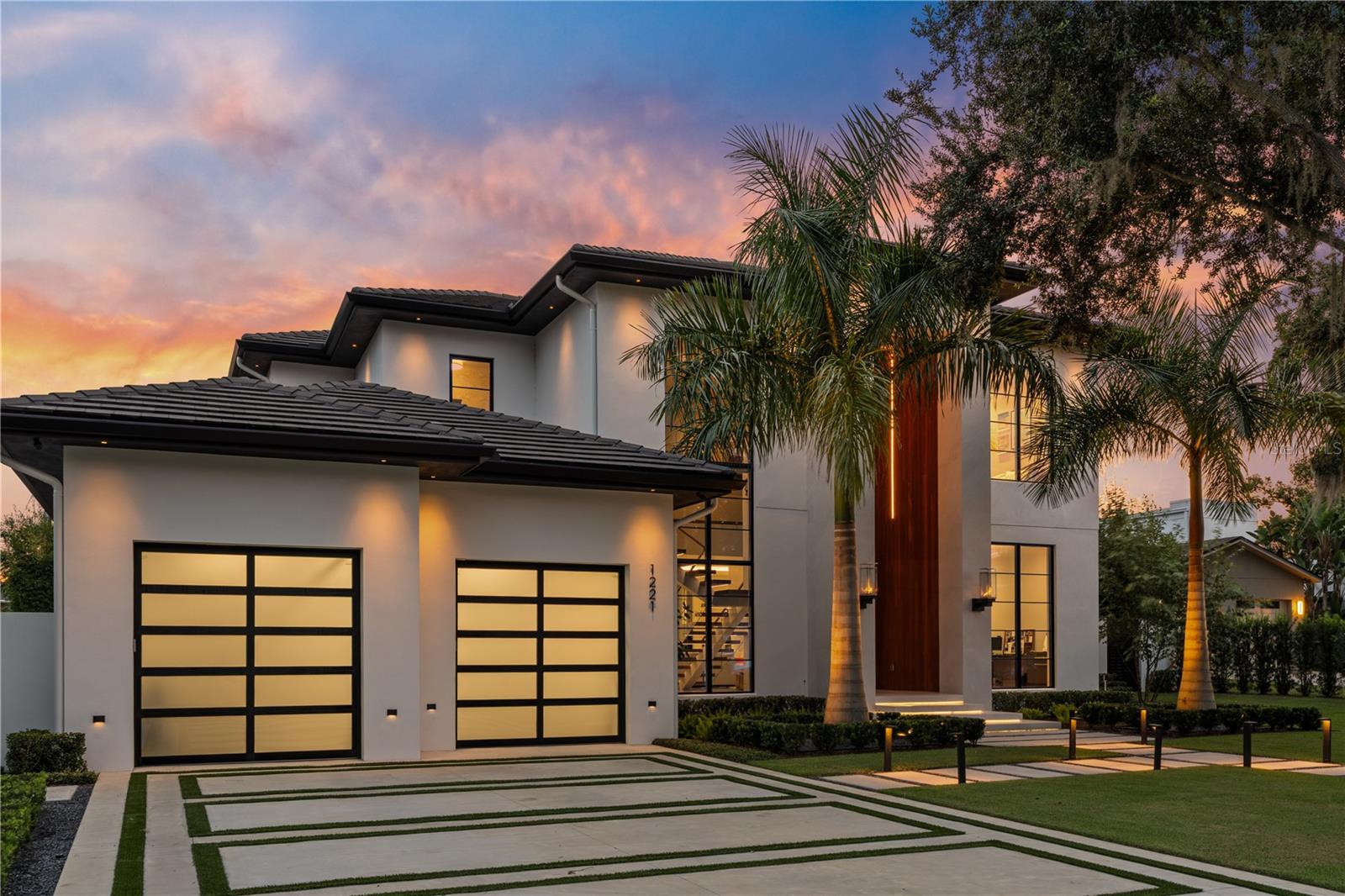 An Award-Winning Architectural Masterpiece built by Chris Salhab of Valdara Custom Homes. 5,164 Sq Ft | 5 Bedrooms | 6 Bathrooms | Welcome to 1221 Richmond Rd, an extraordinary custom residence located in the coveted Virginia Heights neighborhood of Winter Park—offering deeded lake access to the Winter Park Chain of Lakes. This architectural showpiece was honored as the 2024 Parade of Homes Showcase Home – Grand Award Winner and recipient of the Aurora Award – Grand Award for Best Custom Home. Completed in 2024, this 5,164-square-foot estate redefines luxury living with bold design and state-of-the-art technology. A dramatic 10-foot steel pivot entry door with smart glass sets the tone for what lies within—a seamless blend of art, innovation, and elegance. At the heart of the home, a sculptural floating staircase makes a powerful architectural statement, while a 30-foot-wide floor-to-ceiling sliding glass wall opens the interiors to an expansive outdoor living space. The lanai, resort-style pool, and custom-designed entertaining areas create the perfect backdrop for gatherings or quiet retreat. The primary suite is a sanctuary of serenity, complete with a floating center vanity and spa-inspired finishes. Every room has been meticulously curated with high-end materials and modern sophistication, offering an effortless lifestyle that’s both functional and indulgent. Set on a spacious lot just minutes from Park Avenue, this home offers walkable access to Winter Park’s finest dining, shopping, and culture, while also providing private enjoyment of the lakes and lush surroundings. Standout features: Solid core walnut interior doors, Lutron Raw 3 Lighting and shade control, Bespoke custom cabinetry throughout, spray foam insulation w/ interior mineral wool sound control, whole home backup generator, fully automated salt water pool, integrated sonos speakers, deep irrigation well, whole home water purification.
Bold. Bespoke. Award-Winning. Welcome to 1221 Richmond Rd—where architecture, luxury, and lifestyle converge.