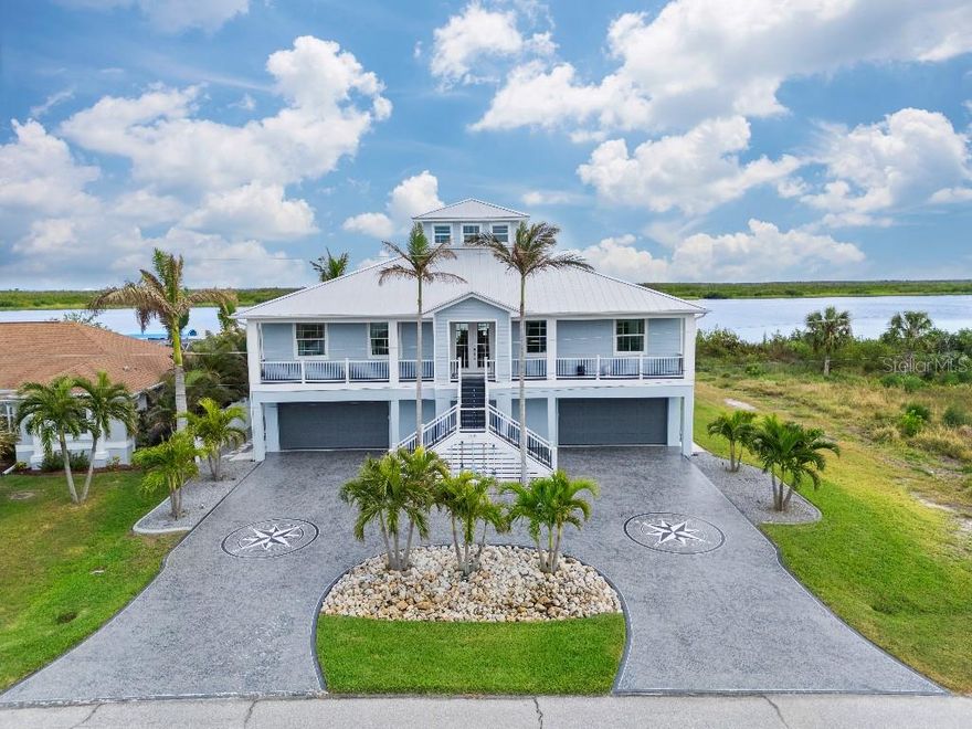 PRIME LOCATION! Presenting this stunning, Key West Style, waterfront home on the desired Lagoon in South Gulf Cove, located minutes from Charlotte Harbor. The front staircase leads to a covered balcony with w/ Wi-Fi lighting and sound. The main entry doors have a retractable screen so you can open the doors to enjoy the perfect day bug free! Have groceries? Take the elevator! Step into the great room ahead with 20 ft of stacking sliders giving you an expansive view of the Lagoon and the preserve to relax and watch wildlife, sailboats and the stunning sunrises. The custom-built entertainment wall boasts a tv niche large enough for an 82” tv, and shadow boxes to display your taste of style. On those rare cold nights, snuggle up with the electric fireplace and turn on the surround sound for an epic movie night. The kitchen is highlighted with quartz countertops, subway tile backsplash featuring an oversized counter height island, cabinetry with under cabinet lights, 2 separate sinks, Frigidaire Professional appliances; cooktop, double wall ovens, standup refrigerator and standup freezer with trim kit, microwave/air fryer, and 2 dishwashers. Also, a full-sized wine fridge and a walk-in pantry. With an adjacent built-in exterior bar area and access to the balcony through stacking sliders, hosting game day is a breeze with the outdoor bar with cabinets, granite countertops, equipped with tv’s, beverage coolers, and ice maker. The retractable motorized screens allow for either clear views or insect protection, depending on the time of day. The upper level boasts 2 separate en suites with walk-in closets, one with a walk-in shower, the other with a tub/shower. The 3rd guest room provides enough space for a King bed and walk-in closet and a privately shared bathroom. The primary en suite offers separate walk-in closets, separate vanities, walk-in shower, and private water closet. Also utilize a half-walled space used for your liking. The lower level provides additional rooms with mini split ac’s, one is used as a gym with sauna and the other room is equipped with kitchen amenities, closet and enough room for a bed and furniture along with an attached full pool bath. With the lower levels generous size, there is an interior breezeway with access to the pool and garages, and equipped with water hookup. Along with a storage area under the interior staircase, there is a large separate storage room on this level. The lanai consists of a Pebble Tec saltwater pool, a heater and an easy-to-use Wi-Fi control system. Enjoy a built-in bench, a sun shelf, a relaxing spa with waterfall, and Travertine decking. Take a break from the pool, have a seat at the bar or in the covered lounge area and enjoy the peaceful sounds of the water fountain wall. A Control 4 sound system is installed throughout the home as well as the beautifully landscaped yard with palm trees and a sandy beach area overlooking the Lagoon. If boating is more your style, then stroll down to the private dock with 3 lifts; an 8k lb covered boat lift, a 25k lb boat lift and a manual lift for a small boat. Other amenities include an AI Security Camera system, a 400-amp service, hook up for backup generator, 3 zone ac system, PGT insulated low-e impact glass, HardiBoard siding, standing seam metal roof, spray foam insulation, hot water recirculation system, and a bug system. Whether you want to explore the scenic canals or boat to dinner or sail into the Gulf, the possibilities are endless!
