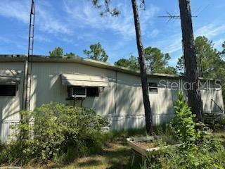 Beautiful partially fenced 5.30 acres zoned A-1 allowing for animals. This property is situated between Ocala and Gainesville. It truly is a beautiful piece of land. The spacious dimensions of the lot are as follows; frontage is 330 and the depth is 699. Lots of aged hardwood trees, a fig tree and flowered landscaping here as well. A livable fixer upper mobile home is also located on the property. A roomy carport which is 8x10 feet giving ample storage for 3 vehicles or equipment. Other storage is 2 sizeable trailers sitting on either side of a sturdy concrete pad once used as a garage of sorts to work on cars. The concrete pad gives easier access to work instead of trying to repair a vehicle with sand underfoot. The big trailers stored the numerous equipment needed to repair the cars. The kitchen has newer cabinetry which just needs a fresh coat of paint. This well built mobile home has a well and a septic tank and both are in perfect working order and presently being used. This home offers privacy, country living and affordability. Ocala is a 30 minute drive away. There is a Dollar General Market and a regular Dollar General about 7 miles away. A public playground is just 7 miles away for the kiddies. Come and take a look at this private paradise. The seller will consider all offers. To get a showing it's as easy as a phone call or text.