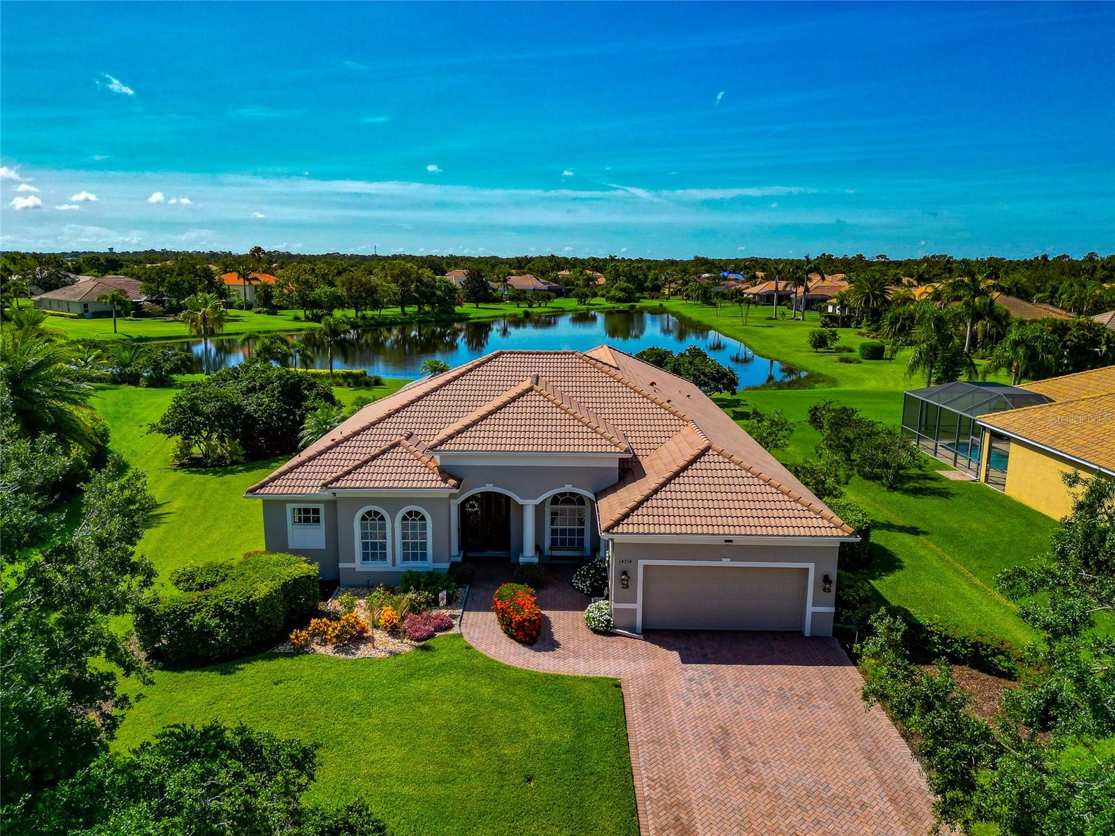 Enjoy long water and garden views from this popular Barbados floor plan by Medallion Homes — a 4-bedroom, 3-bath pool home located on a quiet cul-de-sac in the sought-after community of Country Meadows. Set on an oversized lot with mature landscaping and generous space between neighbors, this home offers privacy, functionality, and room to spread out.
Inside, you’ll find a thoughtful and efficient layout with quality finishes throughout, including ceramic tile floors in the main living areas, coffered ceilings, crown molding, and a dedicated den or home office. The kitchen is designed for both everyday living and entertaining, featuring solid wood cabinetry, granite countertops, stainless steel appliances, a breakfast bar, built-in desk, and an aquarium window in the breakfast nook overlooking the lanai and pool.
The floor plan includes formal living and dining rooms, complete with a butler’s pantry and dry bar. The spacious family room is open to the kitchen and offers direct access to the lanai. A bonus room at the back of the home adds even more flexibility — perfect for a game room, media space, or playroom — and also opens to the outdoor area.
The split-bedroom layout gives the primary suite plenty of privacy, with two walk-in closets and a spacious en-suite bath featuring dual vanities, soaking tub, and walk-in shower. Three additional bedrooms are located on the opposite side of the home, along with two full guest bathrooms — a great setup for families, guests, or multigenerational living.
Step outside to enjoy the screened lanai and sparkling pool, with a large covered patio and peaceful views of the lake and gardens. The outdoor space is ideal for both relaxing and entertaining, offering plenty of room for dining, lounging, or adding an outdoor kitchen if desired.
A rare find in this price range — the tandem 3-car garage is air-conditioned, providing the flexibility for a home gym, workshop, hobby space, or climate-controlled storage while still offering room for your vehicles. Additional features include an interior laundry room with storage and utility sink, and hurricane shutters. The home is move-in ready and has been well maintained.
Country Meadows is a deed-restricted community known for its larger lots, tile roofs, and quiet, well-kept streets. Residents enjoy low HOA fees, no CDD, and a neighborhood playground. Located just east of Lakewood Ranch, it offers quick access to I-75, SR-64, top-rated schools, shopping, dining, and area golf courses — and it’s an easy drive to downtown Sarasota, Tampa, and the Gulf beaches.