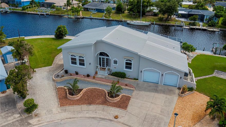 QUICK SAILBOAT ACCESS on an EXPANSIVE 260-FOOT SEAWALL PREMIUM LOT!

Discover this stunning 2006 CUSTOM Key West-style POOL HOME offering 4 bedrooms, 3 bathrooms, and a spacious 2.5-car tandem garage with workshop, perfectly positioned for PANORAMIC WIDE SALT-WATER VIEWS and premium SAILBOATING ACCESS to the harbor and gulf .

Situated at the peaceful end of a cul-de-sac, this remarkable residence makes an unforgettable first impression with its  STUNNING METAL ROOF, soaring covered screened entry, and cathedral sunburst windows that welcome serenity and light.

Boasting nearly 2,700 sq ft of open-concept living space, the home features a formal foyer, an oversized great room with high ceilings and elegant plant shelves, and seamless cross breezes that invite the outdoors in—highlighted by abundant natural light and captivating canal views overlooking the heated pool.

The chef’s kitchen is truly a culinary dream, equipped with granite countertops, tile backsplash, rich wood cabinetry, a convenient breakfast bar, stainless steel appliances including a double oven, and generous storage and prep areas.

The master suite is your personal retreat, offering sweeping saltwater views, a luxurious ensuite bath, and private access to the pool and both elevated and lower patios. Adjacent to the kitchen, a cozy dinette and a spacious den provide stunning sailboat views—perfect spots to unwind and entertain throughout the day.

Three additional beautifully appointed bedrooms offer expansive waterfront vistas, oversized closets , decorator plant shelves, ceiling fans, and durable no-carpet flooring. Two more updated bathrooms serve the bedrooms and main living spaces with style and convenience.

Unique elevated double terrace patios, finished with PREMIUM TREX decking, capture BREATHTAKING SUNSETS and effortless entertaining opportunities from nearly every room.

Additional features include a 2024 dual-zone A/C system, electric  & manual roll-down metal hurricane shutters, elevation certificate, no HOA, extended two-room indoor laundry, public water and sewer, and underground utilities—all providing value and peace of mind.

Enjoy YEAR-ROUND SWIMMING in the generously heated pool, enhanced by serene sunset views. Two private docks with a boat lift offer unparalleled fishing access and swift deep-water entry to the gulf, completing the ultimate Florida waterfront lifestyle.

Located just blocks from Port Charlotte Beach—a hotspot for biking, boating, tennis, volleyball, playgrounds, fishing, and spectacular sunsets—this home is near historic downtown Punta Gorda, the Sunseeker Resort, dining, markets, festivals, airport, and shopping.

Don’t miss this stunning home with oversized wide saltwater-front opportunity  located next to the sought after Grassy Point neighborhood! DON'T DELAY, it's a must-see for those seeking luxury waterfront living.