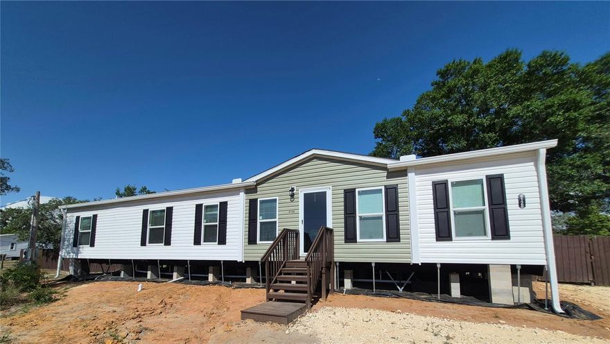WOW! This absolutely beautiful, brand new 2025 manufactured home situated on almost 1 acre of cleared, elevated land, is ready for you and your family!!! The inside features 3 bedrooms, 2 full size bathrooms and an additional 1/2 bathroom. It also features a split floorplan with a Dining/Livingroom/Kitchen combo, an oversized Butler Pantry with built in floating decor shelving and a built in desk perfect for a homework area or home office station. It also features an oversized kitchen Island large enough for entertainment and dining. On one side of the home, you will find your large master bedroom with a beautiful ensuite bathroom featuring a garden bath tub (perfect for soaking after a long days work), a separate shower stall and a large master walk-in closet.  Just down the hall you will find your other 2 bedrooms with a connected Jack and Jill bathroom, a half bathroom and your Utility/Mud Room with a pretty cool built in bench perfect for the work boots and shoes. The outside of the home features a large, fenced in back yard, and a storage shed big enough for all your lawn equipment and/or hobby equipment. This home and land is perfect for those seeking privacy and room to grow, with plenty of space for entertaining and much more! Conveniently located near local amenities while also offering the tranquility of Rural Living. Don't miss this opportunity--Schedule your showing today!