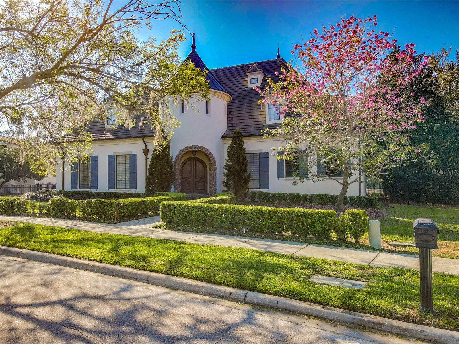 Designed for grand entertaining and intimate comfort, this SPRING PARK RESERVE expansive residence boasts breathtaking pool views, a tranquil pond, and a lush nature preserve. Four spacious bedrooms, plus a versatile office (with a closet) that can serve as a fifth bedroom. 1) ONE FLOOR LIVING EXCEPT FOR A STEP DOWN TO BONUS ROOM. 2) ONE SMALL STEP OUT TO THE POOL DECK. 3) BEAUTIFUL LONG DRIVEWAY TO GET YOUR CARS OFF THE STREET AND PARKING FOR YOUR GUESTS. 4) GUEST SUITE ON 2ND FLOOR. The heart of the home is the gourmet kitchen, featuring custom cabinetry, premium Cambria Quartz countertops, a 48” Sub-Zero refrigerator, a 48” Wolf gas range, a Wolf microwave oven, and Fisher & Payket 2 drawer dishwasher, and a custom exhaust vent to the outdoors. The sunlit breakfast area has unbelievable views. A Beverage Center with a Wolf wine cooler and two beverage drawers, perfect for hosting, connects the dining room with the kitchen with its custom-built cabinets, under-counter lighting, room for two bar stools, and bar sink. The family room, with an impressive gas fireplace, flows directly from the kitchen and opens to the resort-style pool area. The bonus room offers endless possibilities to be a home theater or media retreat, while the formal living and dining rooms provide timeless elegance. Home has a SONOS System for music in several rooms and pool area.
Step into the luxurious primary suite, a serene retreat designed for ultimate comfort and sophistication. This expansive sanctuary features private access to the pool area, allowing for seamless indoor-outdoor living and a freestanding electric fireplace. The spa-inspired en suite bath is a masterpiece of elegances, showcasing a sumptuous soaking tub, an oversized walk-in shower, and dual vanities with Cambria Quartz counters and porcelain tile floors, all thoughtfully designed for both function and indulgence. A private commode room ensures added privacy, while two custom walk-in closets with built-in shelving provide impeccable organization. Every detail of this suite has been curated to an unparalleled living experience where relaxation and refinement go hand in hand. Both secondary bedrooms have en-suite baths; one has a separate shower & tub, and the other has a walk-in shower. The meandering driveway leads to a spacious three-car garage, ensuring privacy and convenience. Tucked away on the second level, a private guest apartment offers spectacular views and ultimate flexibility for extended stay, with a kitchen, living room, full bath, and large bedroom. The pool is heated with a spa & beach area as you enter this gorgeous oasis, all enveloped beneath the screen enclosure. Enjoy the poolside outdoor kitchen, complete with a wet bar & grill station. The property grounds feature mature avocado, lemon and grapefruit trees, artfully placed and a fenced backyard along the pool. Situated in the picturesque town that Disney built, the Town Center is surrounded by 26 miles of scenic walking paths, a charming downtown with restaurants, shops, and its own post office, Advent Health Hospital, Medical buildings, Public Golf Course, 2 Dog Parks, NY-Style Bagel Shop, Coffee Shops, and a Bakery. This exceptional property blends comfort and convenience, an unbeatable location just minutes from Disney and Universal Studios, and endless entertainment.