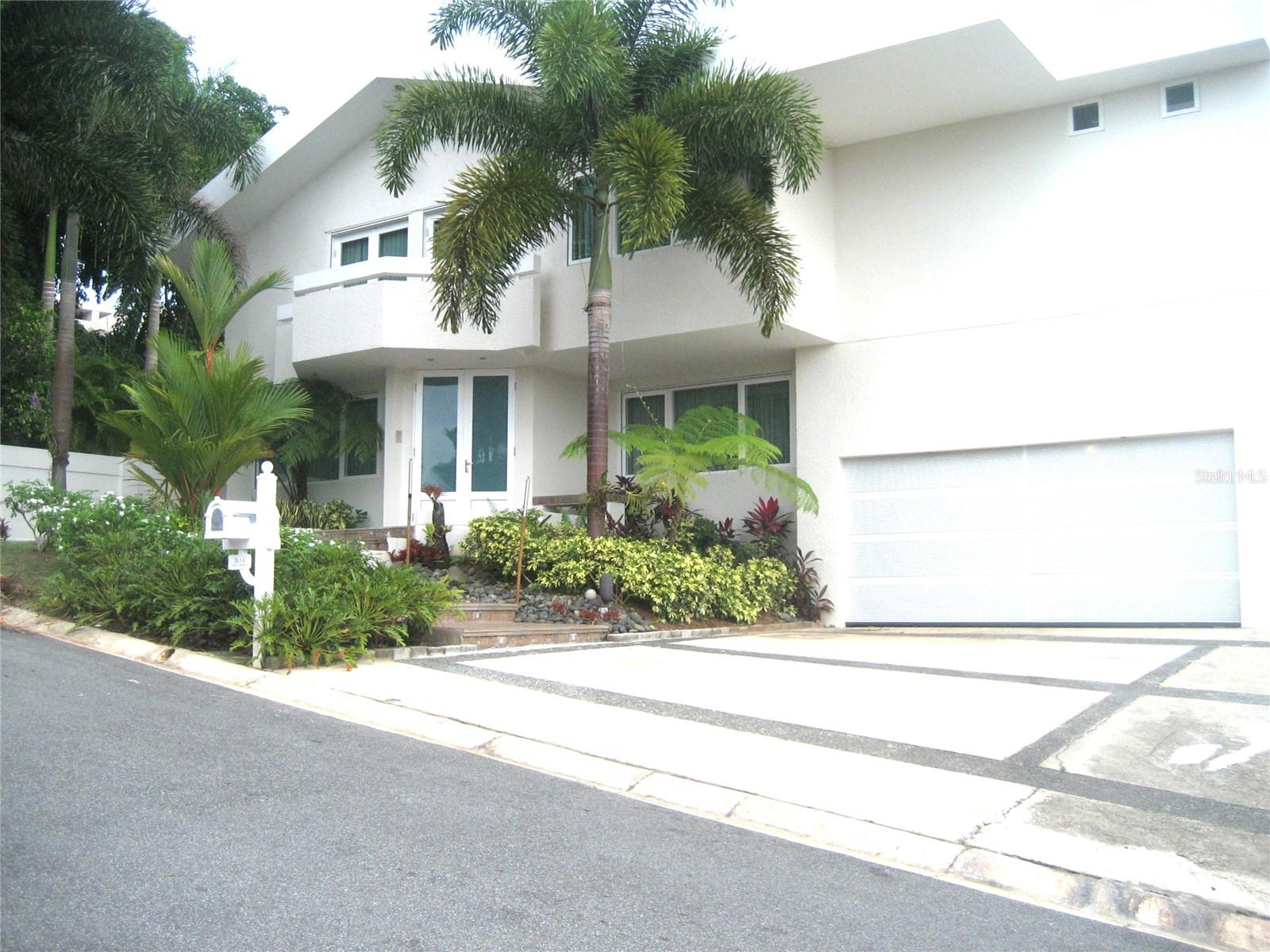 Elegant Modern Home in Baldwin Park in Guaynabo area – Private Cul-de-Sac with Resort-Style Outdoor Living
Located in the exclusive gated community of Baldwin Park, this stunning two-story residence offers the perfect blend of privacy, luxury, and modern design. Situated on a 1,200 m² lot at the end of a quiet cul-de-sac, the home spans approx. 5,000 sq. ft. of impeccably finished living space.
Enjoy luxurious marble flooring throughout the entire home, soaring ceilings, and sun-drenched open-concept living and dining areas. The sleek European-style kitchen features granite countertops, stainless steel appliances, and a spacious island that flows into the inviting family room—ideal for entertaining and everyday living. Additional features include a private cinema room, stylish bar area, secure windows and doors, and a three-car garage.
From the main floor, step out to the expansive primary terrace, showcasing a resort-style pool with salt treatment system, jacuzzi, BBQ area, and panoramic mountain views—your private outdoor retreat.
Upstairs, the home offers 4 bedrooms and 3 full bathrooms, including a luxurious primary suite with spa-style ensuite bath, complete with sauna, whirlpool tub, and walk-in closet. A large office or flex room adds versatile space, and a second terrace on the upper level offers spectacular views of the pool and mountains—perfect for relaxing or entertaining.
Extras include a 25KW gas generator, 400-gallon water cistern, and 24-hour gated security. Conveniently located near excellent schools, shopping centers, banks, and major highways.
A rare opportunity to own a luxurious and private sanctuary—schedule your private tour today!