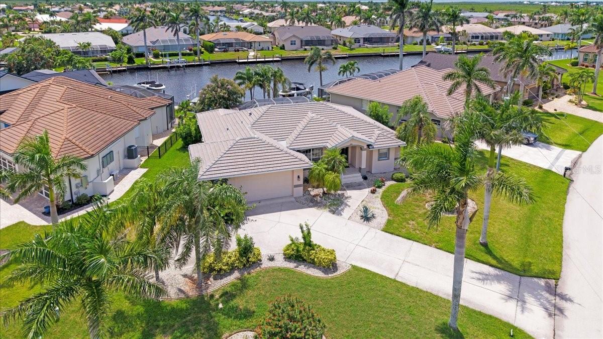 Welcome to this beautifully maintained 3-bedroom, 2-bathroom home located in the waterfront community of Burnt Store Isles. Perfectly designed for comfort, style, and Florida living, this residence comes fully furnished and truly turn-key. From the extended driveway to the oversized 2.5-car garage, there’s plenty of room for vehicles, hobbies, or a workshop. Step through the French doors into a bright, open floor plan filled with natural light. The kitchen is a chef’s delight with granite counters, stainless steel appliances, and a breakfast bar. A cozy breakfast nook overlooks the pool, screened lanai, and canal, while a more spacious dining area is ideal for entertaining. The primary suite is thoughtfully placed on its own side of the home for added privacy and includes direct access to the lanai and pool. It features a walk-in closet and en-suite bathroom with dual sinks, a garden tub, and a separate shower. On the opposite side of the home, two guest bedrooms share a full bathroom—the larger guest room also opens to the pool and lanai. The laundry room is well-equipped with built-in cabinets, ample counter space, and a sink for convenience. Outdoor living is at its finest here. The expansive screened lanai provides plenty of space for dining, barbecues, or simply lounging by the sparkling pool. Accordion shutters on the lanai and manual shutters on windows and doors offer extra hurricane protection. Beyond the pool lies a concrete seawall and city-maintained canal, complete with a private dock featuring water, electric, and a 4,000-pound boat lift. From here, enjoy direct boating access to Charlotte Harbor via Alligator Creek. Residents of Burnt Store Isles enjoy optional memberships to the Burnt Store Isles Association and the Burnt Store Isles Boat Club for enhanced social and boating activities. At the heart of the community, Twin Isles Country Club offers golf, tennis, and dining with membership options. The location is also ideal—close to highways, airports, and historic downtown Punta Gorda’s dining, shopping, and entertainment. This home is the perfect blend of luxury, convenience, and waterfront lifestyle—ready for you to move in and start living your Florida dream.