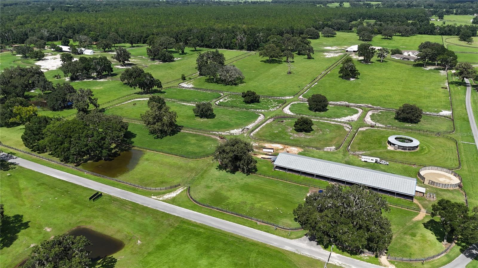 This is your opportunity to own part of the historic Hooper Farm. Located just 7 miles from the World Equestrian Center is this 81 +/- acre farm with 3 large barns and a total of 68 stalls. There are 2 duplexes each with 2 units featuring 2 bedrooms, 1 bath and a 2 car garage. These would be great for guests, clients, or employees. Each unit has their own private courtyard for privacy. The barns are shedrow style barns. There is a round pen, hot walker, and an equipment storage building. The farm would be suitable for a variety of disciplines and uses. There is a yearly fee if you want to the use the 1 +/- mile Nelson Jones Training Track. Many historic horses have been bred, raised and trained on this beautiful farm. This is your chance to own a part of the rich Thoroughbred history of Marion County.
Call today for your viewing appointment of this farm.