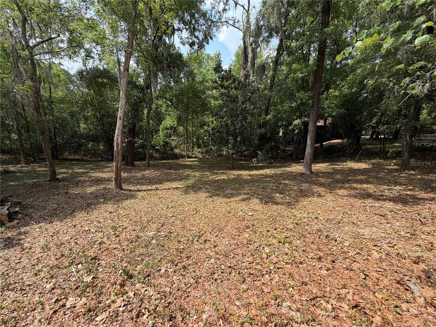 Discover the perfect place for your dream home on this 0.31-acre lot nestled in one of Gainesville's most desirable neighborhoods. This residential Open Builder lot is located in NW Gainesville's Florida Park neighborhood. Exactly one mile from the University of Florida, imagine walking to campus for work or Gator games. The lot measures 135 feet wide and 100 feet deep. The Florida Park neighborhood is a beautiful mix of 1940's, 50's and 60's homes ranging in architectural styles from ranch to Mid-Century Modern and traditional Florida architecture. The sidewalks and close proximity to nearby parks, restaurants and shopping support an active, outdoor lifestyle. Hogtown Creek, mature tree cover and sloping hills make this a very unique setting. Coupled with its close proximity to the University of Florida, UF Health, Downtown Gainesville and Innovation Square, this lot is a rare find. City water, sewer, electric, natural gas, internet and high-speed fiber optic are available. Sellers have a survey, tree survey, topographical survey, soil tests and plans for a custom modern home that blends perfectly into the site. In 2024, the City of Gainesville revised all residential single-family zoning into a common category that allows attached and detached Auxiliary Dwelling Units (ADUs), perfect for multi-family generational living. The lot's rolling hillside, with 10 feet of slow and steady elevation drop from the Northeast to the southwest corners, offers unique views into a wooded conservation area to the south. This topography is especially suited to stem wall, post-and-pier foundations as well as split-level or walk-out basement designs. There is no mandatory HOA; membership is voluntary. Discover one of the last buildable lots in the area with an unmatched location and setting.