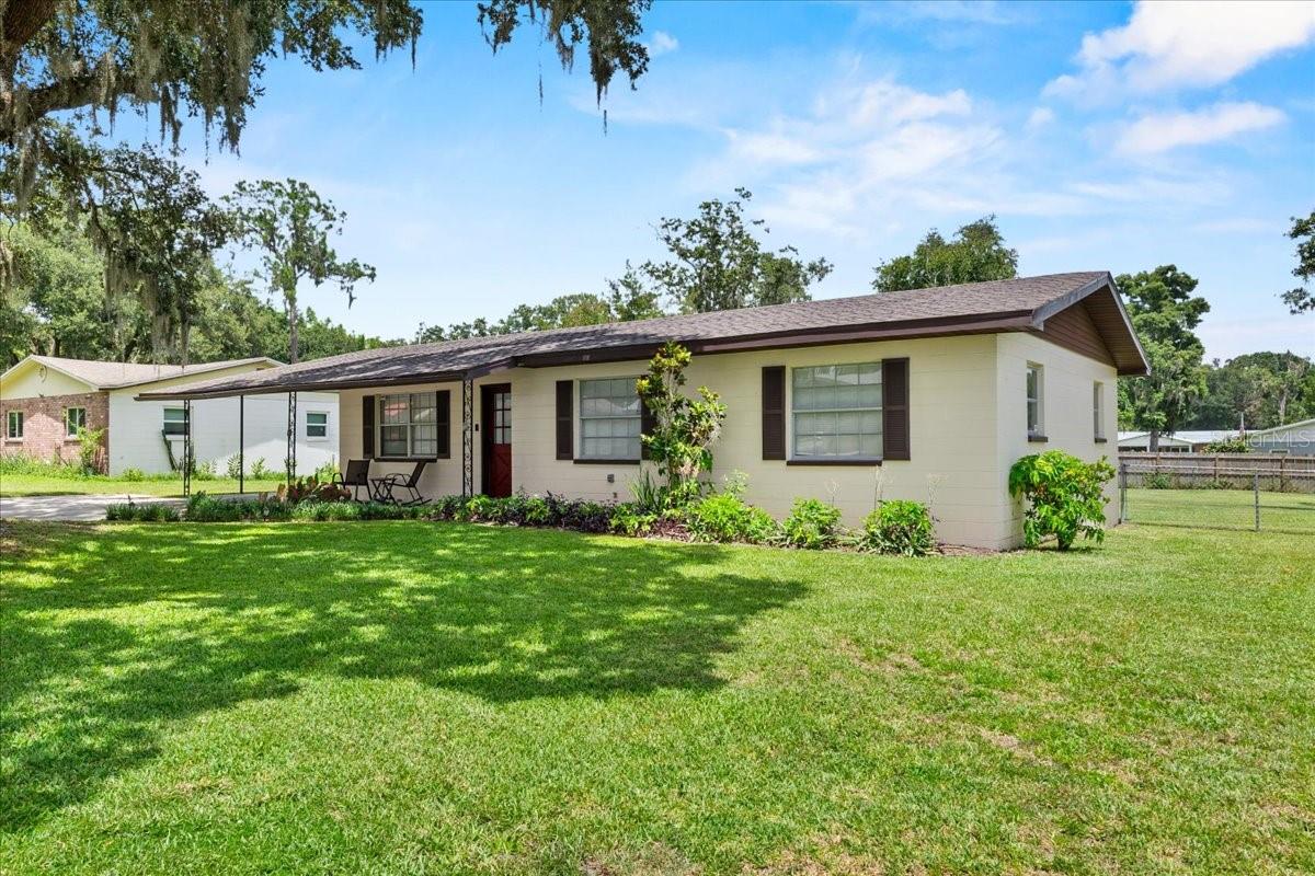 Beautiful 4 Bedroom, 2 Bath Home on a Spacious Corner Lot with a New A/C, New Roof & No HOA!! Welcome to this well-maintained and move-in ready 4 bedroom, 2 bath home, perfectly situated on a generous 0.34-acre fenced corner lot in the heart of Lakeland. With a new A/C system (2024), new roof (2023), and no HOA, this property offers exceptional value, comfort, and freedom. Inside, you’ll find a light-filled and functional layout that includes a spacious great room—ideal for relaxing or entertaining. The well-equipped kitchen features a full appliance package, abundant cabinet and counter space, a tiled backsplash, and a cozy dinette area with space for a table for four. Both bathrooms have been nicely updated, and the home showcases durable hard-surface flooring throughout, ceiling fans, blinds, neutral interior paint, a linen closet, and an oversized hallway storage closet. The private primary suite provides a quiet retreat with an en-suite bath and walk-in shower. Three additional bedrooms offer flexible options for family, guests, or a home office, and the fourth bedroom easily doubles as a game room, den or creative studio. The dedicated interior laundry room includes a washer and dryer for added convenience. Step outside and enjoy a fully fenced backyard complete with a fire pit that is perfect for relaxing under the stars, a patio for weekend gatherings and BBQs, and a storage shed for lawn equipment. Additional exterior highlights include mature landscaping, landscape lighting, a paver walkway leading to the front entry, and a carport with extended driveway for ample parking. Located on the same block as Doris A. Sanders Learning Center and Combee Academy of Design and Engineering, this home is also just five minutes from shopping and dining, and within ten minutes of the Polk Parkway, offering a quick and easy commute throughout Central Florida. This home truly has it all—modern updates, spacious living, outdoor amenities, a convenient location, and no HOA. Don’t miss your opportunity to own this move-in ready gem in Lakeland!