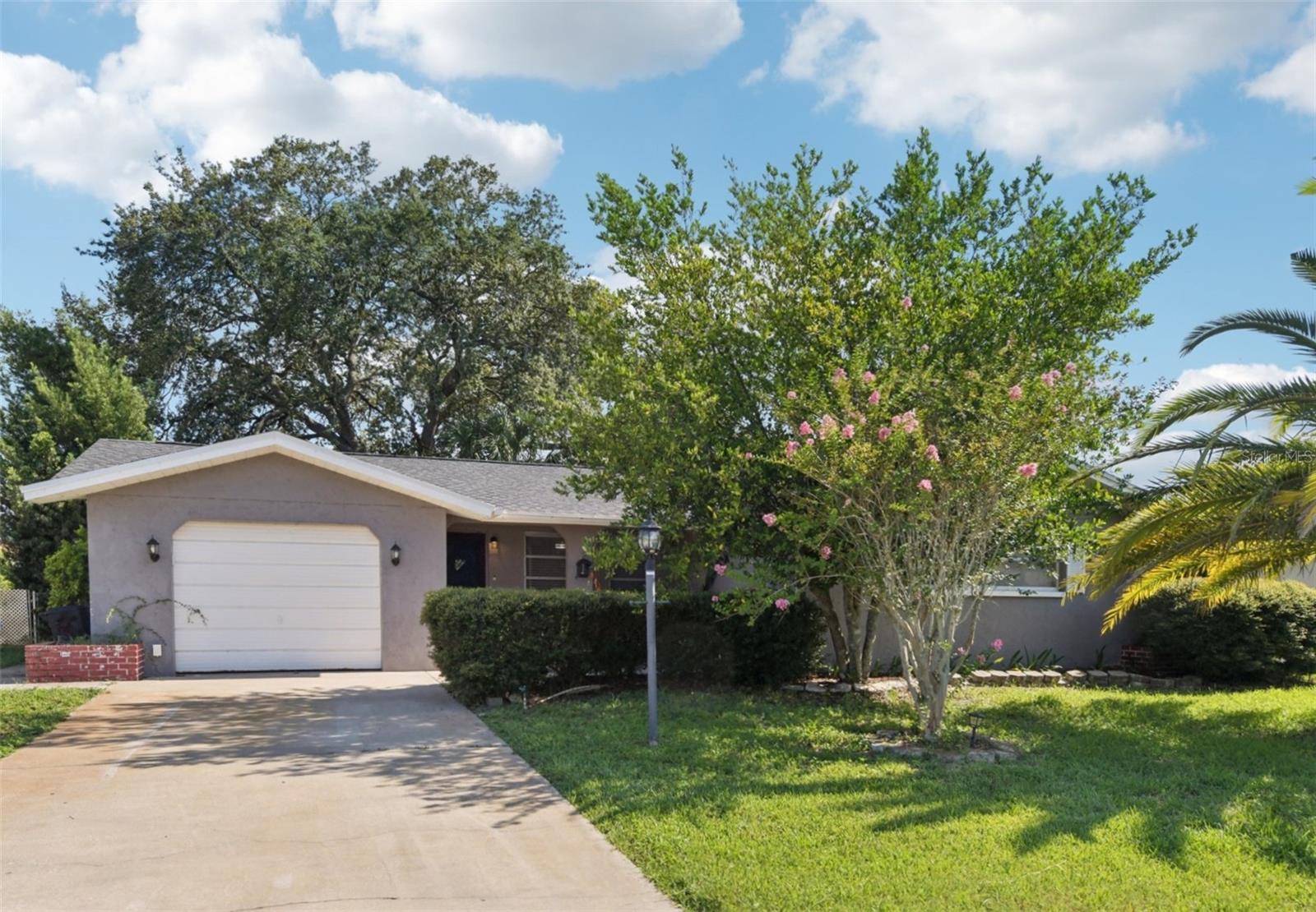 Are you looking for an affordable home that’s already updated and sits along the banks of Double Hammock Creek? This freshwater creek is part of a residential waterway system where you can launch a kayak right from your backyard. The property is in a dual flood zone—the house itself sits in the X500 zone, while the portion of the yard closest to the creek lies in the AE flood zone. Great news: the home did not flood during the last major storms, and the lender doesn’t require flood coverage. Whether you're looking for a family home or a place to host friends, this one is perfect for gatherings. The Living Room, Dining Room, and Bonus Area all connect in an open-concept layout with luxury vinyl flooring and sliding doors that lead to a Florida Room. Step outside to the patio and enjoy evenings around the firepit. Cast a line in the creek and grill up your catch—Largemouth bass, red drum, and common snook are all known to frequent these waters. The kitchen is beautifully updated with granite countertops, a breakfast bar, white shaker-style soft-close cabinetry, modern pulls, stainless steel Samsung appliances, and a farmhouse sink with a sleek sprayer faucet. A bonus room off the kitchen features a wall of windows that frame a peaceful view of the backyard and creek—plus, the kitchen sink overlooks this tranquil setting. All bedrooms are accessed from the main hallway and are generously sized, each equipped with ceiling fans. The large primary bedroom is located at the front of the home, and features an en-suite bathroom with walk-in shower. The two guest bedrooms are near the shared bathroom, which includes a tub and a linen closet. Both bathrooms were updated in 2021 with new vanities, toilets, and fixtures. The laundry room is located in a separate room off the garage, helping keep dryer heat out of the main living area. The one-car garage has space for both parking and storage, and there is also driveway parking. The yard is fenced with gates on both sides of the home. Big-ticket updates include new roof and A/C in October 2021, and the electrical panel replaced in 2011. If you're considering this home as an investment, rentals are permitted with proper licensing and city inspections. Pasco County has no dog breed restrictions, and residents can own up to nine pets without requiring a kennel permit. As you enter the neighborhood, you’ll pass Jasmine Lake, a scenic, fishing-friendly spot perfect for a relaxing afternoon picnic. Multiple nearby boat ramps and kayak launch sites make water access a breeze. You're also just minutes from grocery stores (including organic options), restaurants, and shopping. If you enjoy upscale or waterfront seafood dining, you'll find plenty of great options in Port Richey and New Port Richey. For additional recreation check out Werner Boyce Salt Springs State Park (Port Richey): Enjoy trails through coastal wetlands, boating, fishing, wildlife viewing, and picnic areas with Gulf access. Sunset Beach and Fred Howard Park are the closest beaches. The New Port Richey Recreation & Aquatic Center is a full-featured facility with four outdoor pools, indoor playground, basketball and pickleball courts, fitness center, showers, and concessions. Day passes available for your non-resident guests. If you want to live just outside the hustle and bustle of Pinellas County, benefit from lower taxes, and still enjoy the outdoor Florida lifestyle, you’ve found the perfect place to call home.