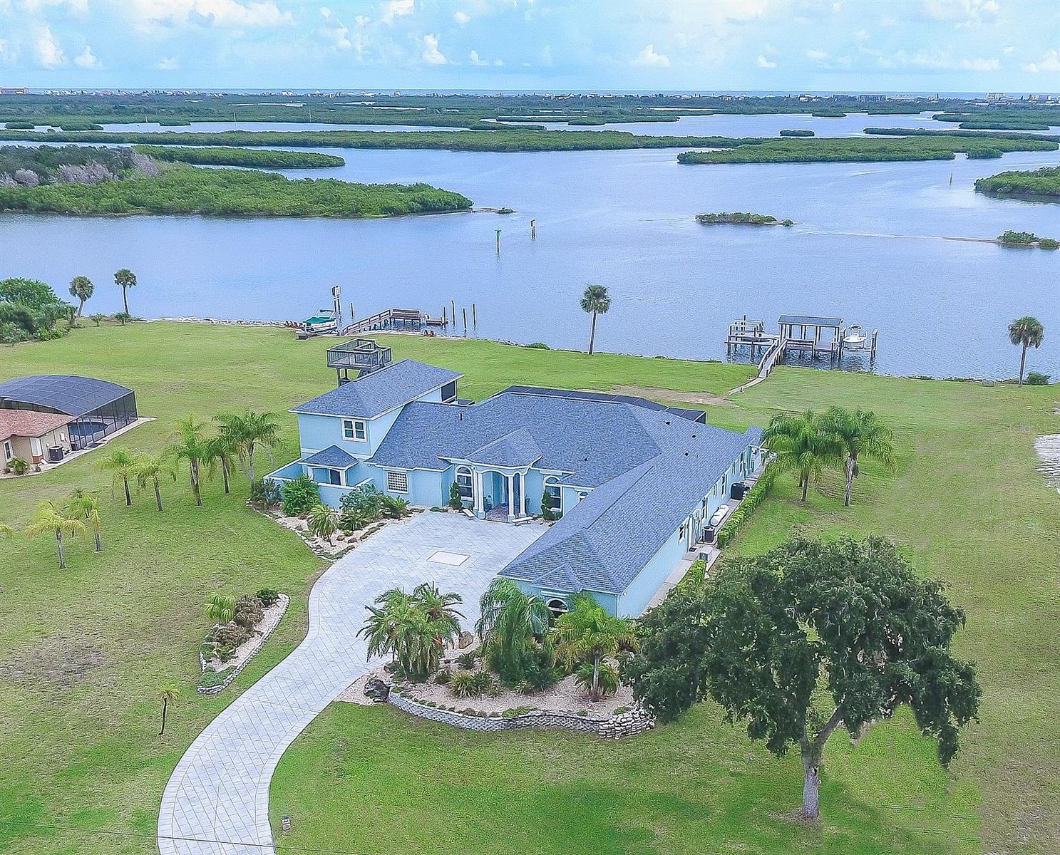 FABULOUS ONE OF A KIND DIRECT INTRACOASTAL ESTATE HOME. ONLY A 12 MINUTE DRIVE TO CANAL ST IN NEW SMYRNA AND 18 MINUTES TO FLAGLER AVE AND BEACH. LOCATED ON 5+ ACRES w/OVER 250 FT DIRECT INTRACOASTAL FRONTAGE AND UNOBSTRUCTED PANORAMIC VIEWS OF THE RIVER. THE COVERED BOAT DECK HAS TWO BOAT LIFTS w/A FLOATING DOCK ON DEEP WATER FOR ALL YOUR WATER TOYS. THIS 2006 CUSTOM BUILT RESIDENCE HAS 6 LARGE BEDROOMS (one bedroom is being used as an office), 6 FULL BATHS, CLUB/GAME ROOM, GOURMET KITCHEN, 4 CAR OVERSIZED GARAGE, INGROUND SCREENED SALTWATER POOL & SUMMER KITCHEN. THE GOURMET KITCHEN INCLUDES A BUTLERS PANTRY, SEPARATE WALK IN PANTRY, TOP OF THE LINE 6 BURNER GAS WOLF RANGE, SUBZERO REFRIGERATOR, BOSCH DISHWASHER, CUSTOM MADE CABINETS & CENTER ISLAND. THE OPEN FLOOR PLAN WAS DESIGNED TO FEATURE WINDOWS WITH SPECTACULAR RIVER VIEWS FROM EVERY ROOM. THE OUTDOOR ENTERTAINMENT AREA INCLUDES AN OVERSIZED SCREENED, SALT WATER POOL & SPA AND AN OPEN SEATING AREA WITH A 7 FT CUSTOM GRILL AND GAS FIRE PIT. THE MAIN BEDROOM IS A RETREAT OF ITS OWN w/SITTING ROOM, PRIVATE SCREENED PORCH, SEPARATE DRESSING AREA, 20X20 CUSTOM CLOSET, HIDDEN SAFE ROOM, COFFEE/REFRESHMENT CENTER, AND EN SUITE WITH SOAKING TUB, LARGE WALK-IN SHOWER, BIDET AND LOTS OF VANITY AREA. THE SPECTACULAR FIRST FLOOR LIVING AREA IS COMPLETE AND COMFORTABLE JUST AS IT IS... HOWEVER THERE'S A BONUS AREA UPSTAIRS WITH A CLUB/GAME ROOM, CUSTOM BAR, SCREENED PORCH AND A PRIVATE BEDROOM AND FULL BATH. THE 3RD FLOOR OBSERVATION TOWER OFFERS TRULY AMAZING VIEWS OF THE RIVER & OCEAN AND THE BEST PLACE TO SEE ROCKET LAUNCHES. STATE OF THE ART SECURITY SYSTEM COMBINED w/THE POWERED GATED ENTRANCE PROVIDES YOU CONTROL OF YOUR PRIVACY. MANY EXTRAS INCLUDE BRAND NEW UPGRADED PGT HIGH WIND IMPACT TINTED WINDOWS AND GLASS DOORS, PLANTATION SHUTTERS, WHOLE HOUSE GENERATOR, POWER HURRICANE SHUTTER SYSTEM, NEWLY PAINTED INSIDE AND OUT, RV PARKING AND LOTS MORE. SHOPPING NEARBY AT PUBLIX & WALGREENS. ;Water: City