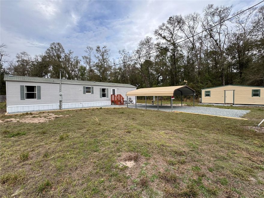 Located in the desirable Three Rivers Estates community, this 2-bedroom, 2-bath manufactured home sits on nearly 2 acres surrounded by dense natural woods, offering a private and peaceful setting. Built in 2001, the home features a functional layout with a full kitchen that includes an island, refrigerator, oven, microwave, and stainless steel appliances. Recent updates include new flooring, updated kitchen cabinets, freshly painted interior, new drapes, and newly stained front and back steps. The exterior has been improved with new skirting and freshly laid gravel in the front of the home and around the covered two-car carport. Additional features include a large storage shed, private well and septic system, and ample outdoor space to enjoy the natural surroundings. Deer are frequently seen on the property, adding to the tranquil setting. The property is conveniently located near several nearby Florida spring parks, including Ichetucknee Springs State Park and Gilchrist Blue Springs State Park, offering easy access to outdoor recreation such as swimming, kayaking, and hiking