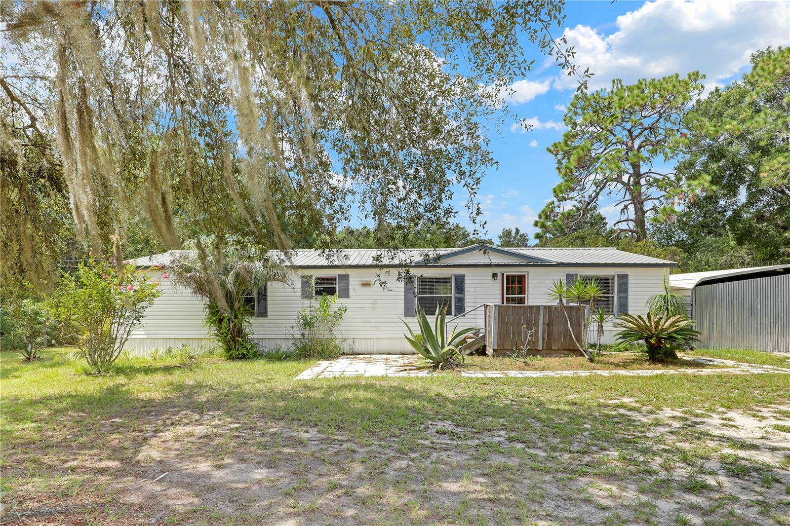 Under contract-accepting backup offers. **1 ACRE LOT**SPLIT BED FLOOR PLAN**Enjoy the peace and quiet in the countryside with this 3 Bed/2 Bath home that is situated on a 1 acre lot. This property is GATED, offering a peace of mind. This home boasts a desirable split bedroom floor plan, ideal for privacy. The large living room, which is equipped with a FIREPLACE, offers ample opportunity for entertaining family and friends. The kitchen provides tons of counter space, as well as lots of cabinetry. Enjoy your meals in the cozy breakfast nook off of the kitchen. The SPACIOUS BEDROOMS offer extra relaxation. The LARGE FRONT YARD is perfect for sunny Florida days and nights outside. The property comes with a carport and 2 sheds as well for additional, outdoor storage space. Embrace rural living on this cozy property! Don’t miss out!