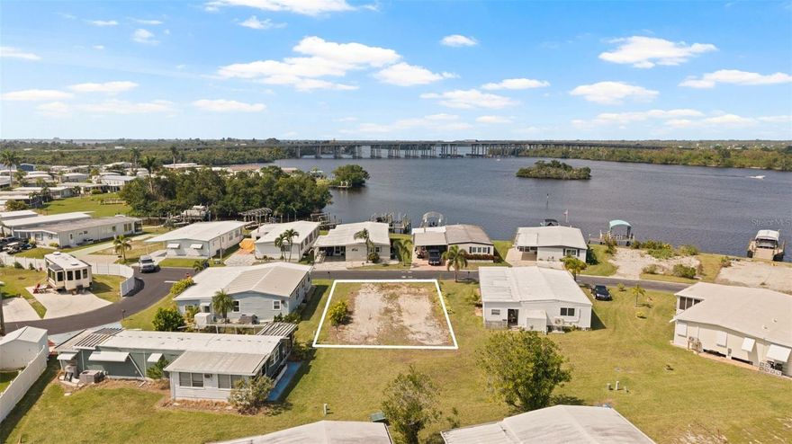 Breathtaking views abound from this oversized 45 x 120 sq. ft lot located across the street from the Caloosahatchee River. New modular home would be built up to current regulations with parking underneath. Lot would hold a home up to 1800 sq. ft. Build a garage, shed, lanai or a combination underneath. This is the retirement home/lot that you've been dreaming of! Not ready to build yet, then purchase the lot at today's lower price since it's a strong buyer's market until you're ready to build! Price includes share for the lot and ownership in the co-op. Low monthly maintenance fee of $406 includes water/sewer, lawn mowing, trash pick up, fiber optics internet, gated entry, professional management, private streets and all amenities including clubhouse, heated pool, two private boat ramps, fishing dock, pickleball courts, heated pool and many clubs and activities. Orange Harbor is a beautiful 55+ waterfront community located along the Orange and Caloosahatchee Rivers. Built in 1960, the community has 365 homes and a 140 space RV park. Dog and cat friendly. Located on Palm Beach Blvd with grocery and shopping minutes away, downtown Ft Myers is only 15 mins and beaches are 25 mins. Community is known as one of the most beautiful in the Ft. Myers area.  Owners are realtors and modular home dealers and can assist or answer questions regarding a new home!