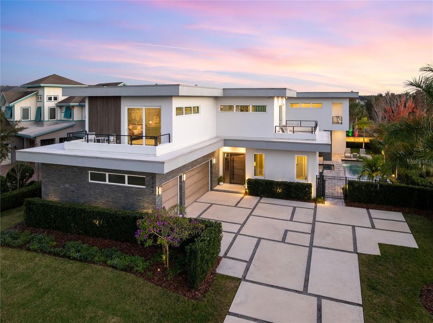 Stunning Custom Modern Estate with Pond Views in Laureate Park

Located on a premier corner cul-de-sac lot in the heart of Laureate Park, this custom-built modern estate offers nearly 4,500 square feet of refined living with serene pond views and seamless indoor-outdoor flow. Clean architectural lines, soaring ceilings, and wide-plank flooring set a dramatic tone upon entry.

The open-concept main living areas are filled with natural light and anchored by a chef’s kitchen featuring solid wood cabinetry, stone countertops, built-in appliances, an oversized island, and a walk-in pantry—ideal for everyday living and entertaining. The first floor also features a private office, a guest en-suite bedroom with full bath, and a dedicated pool bath, offering exceptional flexibility and convenience.

Oversized sliding doors open to an expansive covered lanai with wood-paneled ceilings, recessed lighting, and ceiling fans. The private backyard is a resort-style retreat with a sleek custom pool and spa, expansive paver decking, lush landscaping, and tranquil water views. A fully equipped outdoor kitchen with built-in grill, vent hood, stone counters, and bar seating completes the space, enhanced by a whole-yard app-controlled Thermacell system.

Upstairs, a spacious loft opens to a covered balcony overlooking the pond. The primary suite is a private sanctuary featuring its own balcony, spa-inspired bath with freestanding soaking tub, glass-enclosed walk-in shower, dual floating vanities, and a custom walk-in closet. A dedicated tankless water heater serves the primary suite and kitchen.

Additional highlights include generously sized bedrooms with en-suite options, a whole-house water filtration system with drinkable water at every faucet, custom Lutron motorized shades with select blackout features, professionally wired ceiling sound system, and an oversized three-car garage with epoxy flooring.

Enjoy the Laureate Park lifestyle with access to resort-style pools, Aquatic Center, LP Fit gym, parks, dog parks, and over 44 miles of trails. Centrally located in Lake Nona near Medical City, Nemours, the VA Hospital, dining, shopping, Orlando International Airport, USTA, and major highways.