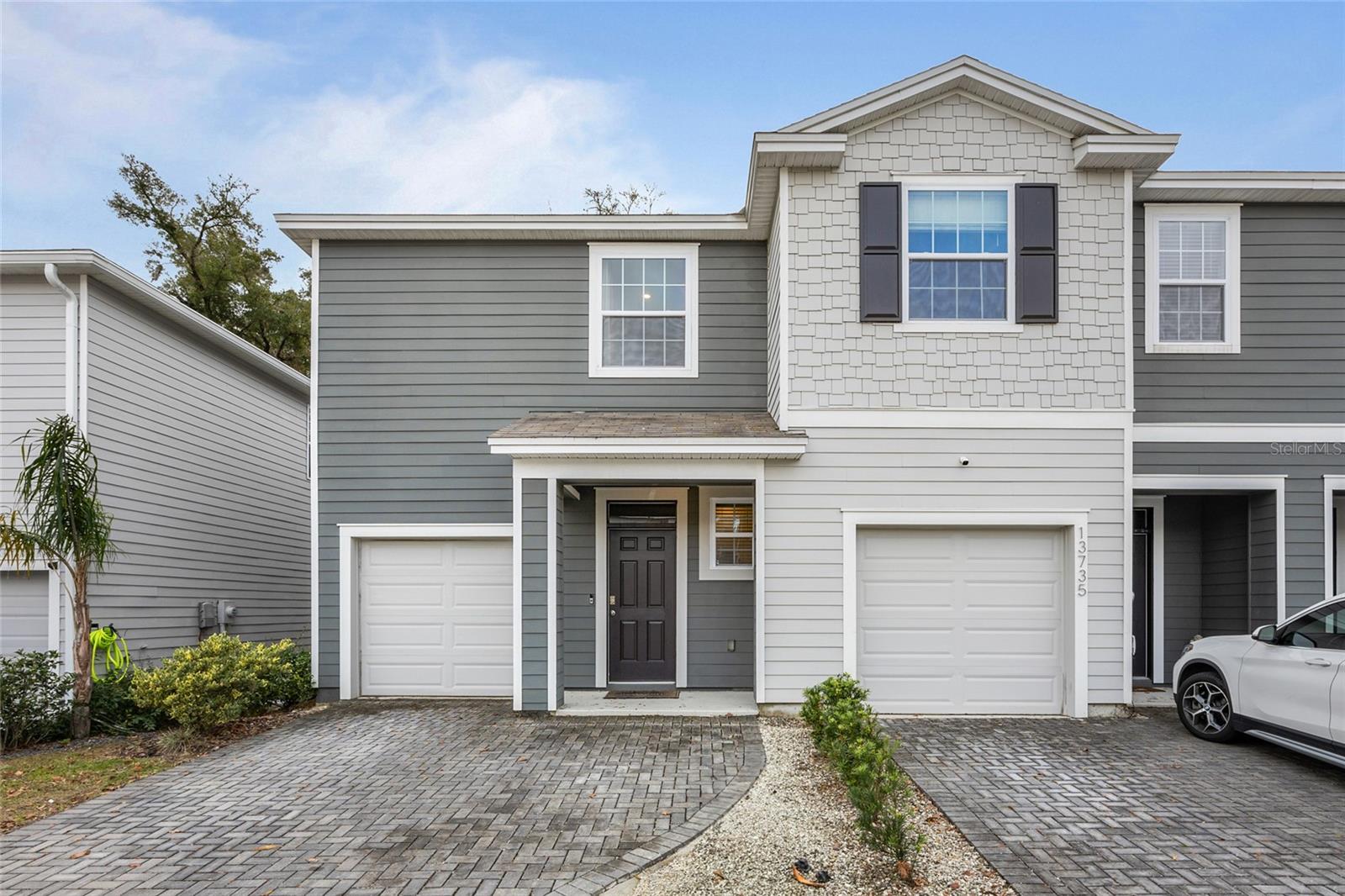 This charming END UNIT townhome has 3-bedrooms and 2.5-bathrooms, plus a 1-car garage which creates the perfect blend of comfort and style. Step into the spacious foyer, offering a convenient drop-zone area for daily essentials. The open floorplan is light and bright, seamlessly connecting the kitchen, dining area and great room. The kitchen boasts granite countertops, stainless steel appliances, ample cabinetry ideal for all your culinary needs, a large functional island providing additional seating and pantry. The designated dining area transitions seamlessly to the expansive great room featuring collapsible sliding doors that open to the private screened lanai overlooking green space, creating a serene indoor-outdoor living experience. A half bath completes the main floor. Upstairs hosts a versatile flex space, perfect for an office, playroom or secondary living area. The split floorplan ensures privacy, with the primary bedroom offering two walk-in closets and en-suite bathroom featuring dual vanities and a walk-in shower. The two additional bedrooms both with wall closets share a Jack-n-Jill style bathroom with large vanity, tub/shower combo and linen closet. Laundry closet with shelving for additional storage and one car garage with 240-outlet to support EV charger and extended paver driveway for additional parking. This home is in a prime location with easy access to grocery, dining, parks, and entertainment. Quick commute to I-75, UF and Shands. Don't miss the opportunity to make this beautifully designed townhome your own!