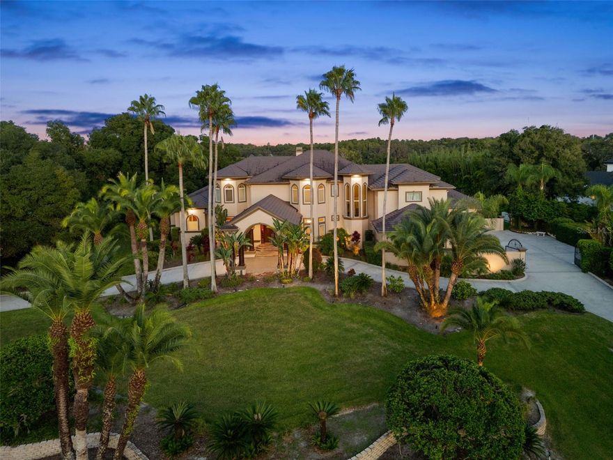 Under contract-accepting backup offers. Luxurious Estate in Châteaux des Lacs: A Rare Opportunity w/ a Private Boat Slip on Lake Tarpon! 
Welcome to a one-of-a-kind retreat nestled in the prestigious gated subdivision Châteaux des Lacs, an elegant enclave where privacy, grandeur & impeccable craftsmanship unite. This spectacular residence spans nearly 8,000 sqft of living space & sits up on a 1.65-acre lot, offering room to roam, entertain & indulge. 
This perfectly appointed home features 5 ensuite bedrooms, including a main-floor primary retreat; 6 full & 3 half baths + a 4-car garage w/ private gated entry. The grand foyer leads to multiple formal entertaining spaces: dining room, formal living & a home office/library w/ floor-to-ceiling bookshelves, custom built-ins & coffered ceilings. Entertainment & leisure spaces include a game room w/wet bar, wine cooler, beverage center & ice maker; in-home fitness center complete w/all equipment; fully outfitted home theater/media room w/dry bar, microwave & beverage center; loft & screened balconies w/spiral staircase extending your outdoor living. The chef’s kitchen showcases stacked solid wood cabinetry w/custom pullouts, glass door accents, under-cabinet lighting, beautiful Quartz countertops w/ waterfall island edge, large single bowl apron sink, stainless steel Monogram appliances, gas range w/griddle & custom hood, double-drawer integrated dishwashers, built-in Miele espresso machine, dedicated desk area & a spacious breakfast nook. The primary suite offers a sitting area, granite fireplace, dual custom walk-in closets, mirrored dressing area, steam shower, dual vanities & a stunning footed tub. Notable finishes include Raja slate, mahogany & marble flooring, custom millwork, inverted tray ceilings, designer lighting, surround sound ceiling speakers throughout, double washer/dryers, dog wash station & more! Recent updates include: upstairs AC(2025), downstairs ACs('20/'17), water heaters('22/'24), several new windows(2025), pool equipment(2025), landscape lighting(2024), exterior paint(2024), lifetime aluminum roof & whole-house automatic Generac generator(2025). 
Outdoors, enjoy a private tropical oasis w/resort-style pool & spa, impressive grotto waterfall feature, sun shelves, PebbleTec surface, saltwater chlorination, solar heating, LED lighting & paver decking. The expansive screened lanai features tongue-and-groove ceilings, outdoor kitchen/bar w/granite countertops, beverage center, gas grill & stainless hood, misting fans & a full pool bath w/ample storage. The sprawling backyard is beautifully landscaped, fenced, w/mature trees & stunning landscape lighting. 
Châteaux des Lacs, French for “Castles of the Lakes,” is a guard-gated enclave situated on the northern tip of Lake Tarpon, w/an exclusive community dock & one of few deeded boat slips private to this home! Beyond the gates, you’ll find world-class golf at Innisbrook Resort, charming shops & authentic Greek dining at the iconic Tarpon Springs Sponge Docks, A-rated public schools & everyday conveniences within minutes. Outdoor lovers appreciate quick access to Brooker Creek Preserve, Fred Howard Park & world renowned white sand Gulf beaches; while commuters enjoy easy connections to Tampa International Airport, downtown Tampa, and St. Pete; all within 30–45 mins. From boating & beaches to fine dining & boutique shopping, Châteaux des Lacs places you at the center of it all, while still offering the peace & prestige of a true estate community!