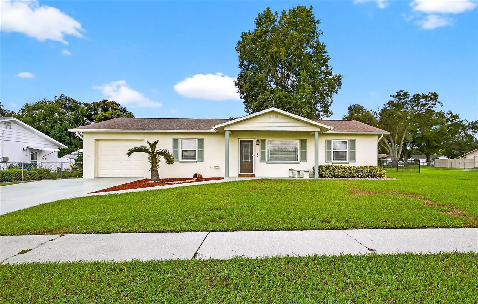 Beautiful home on large fenced corner lot! Enjoy a little bit of country but close enough to bustling Zephyrhills! 2 bedroom, 2bathroom home with gorgeous engineered hardwood floors through out. Complete new HVAC system installed Feb 2023, Newer interior windows, complete kitchen renovation w/stainless appliances(Microwave 2025), granite counters, back splash and shaker style cabinets. Same for the bathrooms, new vanities, toilets, tile backsplash 2018. Enclosed sunroom to relax and enjoy mornings or evenings. Large back yard for possible garden, pool or playset!!! Oversized driveway
