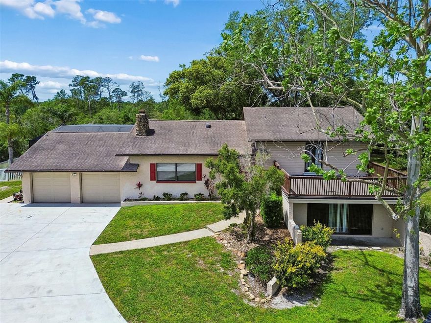 Located in the highly desirable Tanglewood East community, this property offers the kind of space, privacy, and peaceful setting that buyers searching for land are actively chasing. Known for its larger homesites and quiet, tucked-away feel, Tanglewood East delivers true tranquility while still being just minutes from shopping, dining, and everyday conveniences. Privately positioned on an elevated homesite, this 5-bedroom, 4-bath home provides flexibility and function with a tri-level layout, two primary suites, and multiple living spaces that can easily adapt to an office, gym, or media room. The main living area is centered around a striking stone wood-burning fireplace and flows seamlessly into the kitchen and dining space, creating an ideal setup for both daily living and entertaining. Outside is where this property really stands apart. The backyard is designed for both relaxation and functionality, featuring expansive paver decking, a screened pool with PebbleTec finish and sun shelf, and a covered pergola lounge area. A detached workshop, additional outbuilding, and ample storage provide the kind of versatility that’s hard to find. For buyers looking for privacy, usable space, and a true lifestyle property in Tanglewood East, opportunities like this are few and far between. (ROOF-2011)(A/C-1998 & 2009)(W/H-2026)(WELL PUMP-2020)