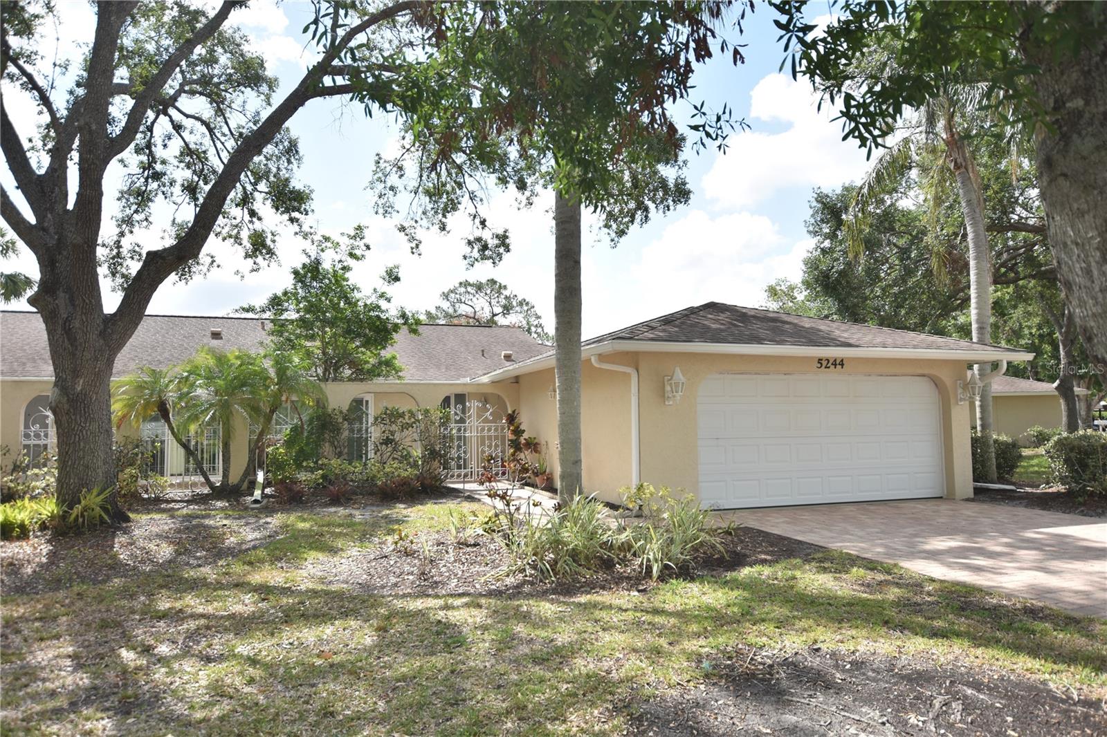 Convenience of condominium Villa but lives like a single-family home with paver drive and 2 car garage. Step through the wrought iron gated, paver brick courtyard entrance and into this well maintained spacious, light and bright, 2-bedroom villa with den. Lots of added living space with impact glass enclosed Florida room with tile floor and lovely views of greenbelt of mature landscaping. Many updates include impact sliders and windows front and back 2019. Cast iron drainpipes were replaced with PVC 2014, garage door 2014, new HVAC in 2023, Water heater 2022. Kitchen has brand new refrigerator, range and microwave. The Meadows is a resort-lifestyle community 15 minutes from downtown with 1,600 park-like acres. Residents enjoy 14 miles of biking and hiking trails, fun-filled activities, fitness center, Junior Olympic pool, pickleball courts, dining venues. The private Meadows Country Club offers a variety of memberships for golf. The Meadows community is a prime location that places you near award-winning beaches, remarkable arts and culture, Nathan Benderson Park, Mote SEA Aquarium and The Mall at University Town Center, a world-class shopping, entertainment and dining destination. A fabulous Florida lifestyle awaits. Villa Majorca is a neighborhood of 31 villas with its own heated community pool.