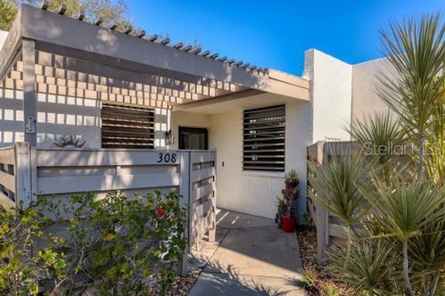 WOW! The minute you walk in the door of this 3/2 one story villa, you are immersed in a tranquil panoramic lake view. This well-appointed home is turnkey furnished, provides a deeded carport, assigned open parking space, and additional guest parking. The designer kitchen has shaker cabinets, beautiful quartz counters, and Wi-Fi enabled stainless appliances including induction stove top and convection oven.
The spacious counter-height breakfast bar has seating for four. The open dining room has a dry bar with wine rack. The living room has a wall of hurricane-grade windows with a full view of the lake. Step through the sliding doors to the L-shaped lanai/Florida room, with a locked storage closet, to take in the amazing 180 degree views of the lake from sunrise to sunset. 
The expansive master bedroom also has sliding glass doors to the lanai/Florida room offering views of the lake, a large walk in closet and an ensuite bathroom with tub and shower. The second bedroom is spacious with a large closet. There is a guest bathroom with a walk in shower. The third bedroom/den, has a queen-size murphy bed, sliding doors to the lanai with lake view and a built in closet. What ever fits your needs. There is also a paved pergola court yard with barbecue grill at the entrance of the home.
Wildewood Spings is a beautifully maintained Audubon certified sanctuary with pools, tennis and pickleball courts. Close to Anna Maria Island and Beaches, IMG, Golf courses, SRQ airport, restaurants and shopping.