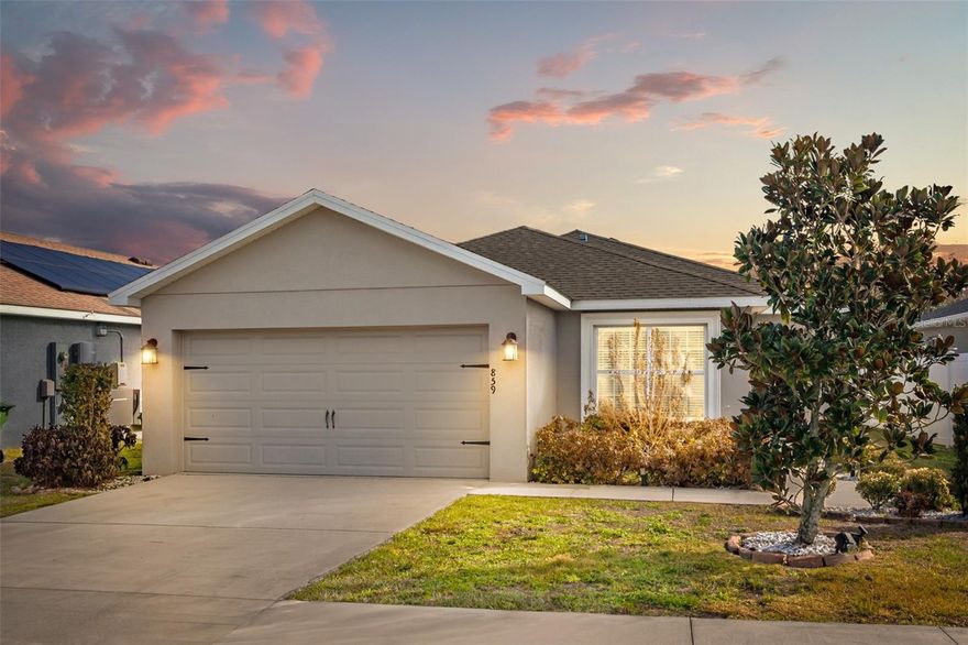 Welcome to 859 Orleans Dr in Eagle Lake, a beautifully maintained 2020-built home that truly feels like new thanks to being lightly lived in as a second residence. Step inside and you’ll immediately notice the stylish vinyl flooring and soaring vaulted ceilings that create a bright, open living space perfect for both relaxing evenings and entertaining guests. The neutral paint palette throughout makes this home completely move-in ready and easy to personalize. The kitchen features solid wood cabinetry, stainless steel appliances, and a layout designed for everyday convenience and functionality. The primary suite offers a comfortable retreat with a generously sized bedroom and walk-in closet, while outside you’ll find a spacious, partially fenced backyard ideal for pets, gatherings, or simply enjoying Florida sunshine.
Located just minutes from both Winter Haven and Lakeland, this home puts you close to some of Central Florida’s best dining, education, and entertainment options. In downtown Winter Haven, spots like Lucille’s American Café are known for made-from-scratch comfort food and craft cocktails using fresh ingredients. For attractions, Winter Haven is home to LEGOLAND® Florida Resort, a massive 150-acre family destination featuring more than 50 rides, shows, and attractions plus a water park and hotels, making it a major draw for residents and visitors alike. The area is also known as the “Chain of Lakes City,” with around 50 lakes offering boating, fishing, and outdoor recreation, along with charming downtown shops and markets. For higher education, residents are within driving distance of major Central Florida institutions such as Polk State College campuses and Southeastern University in Lakeland, providing strong local options for continuing education and workforce development. If you’re looking for a newer construction home with minimal wear, modern finishes, and convenient access to everything Central Florida has to offer, 859 Orleans Dr is a fantastic opportunity to own a home that blends comfort, location, and lifestyle.